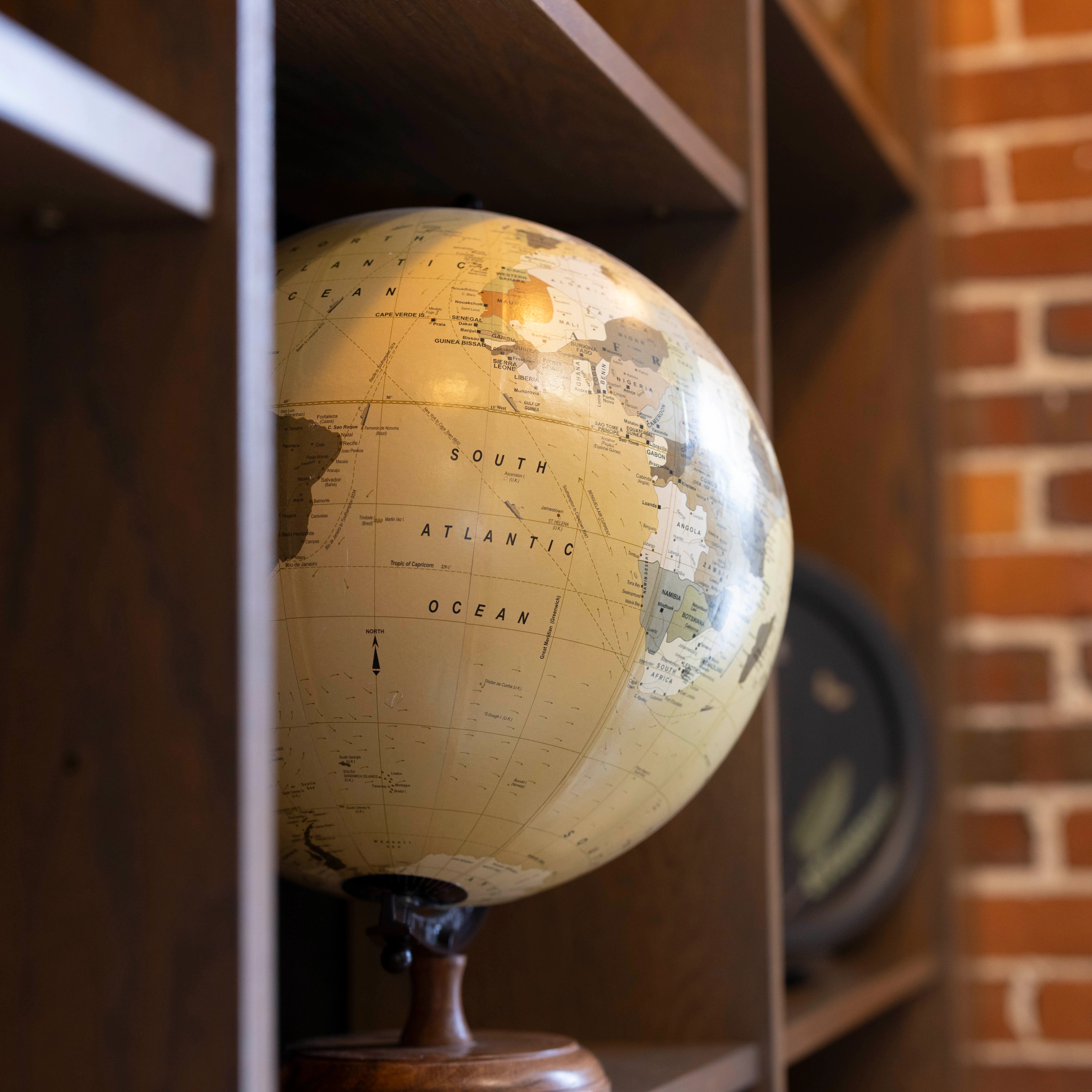 Vintage globe on a wooden shelf in a cozy restaurant