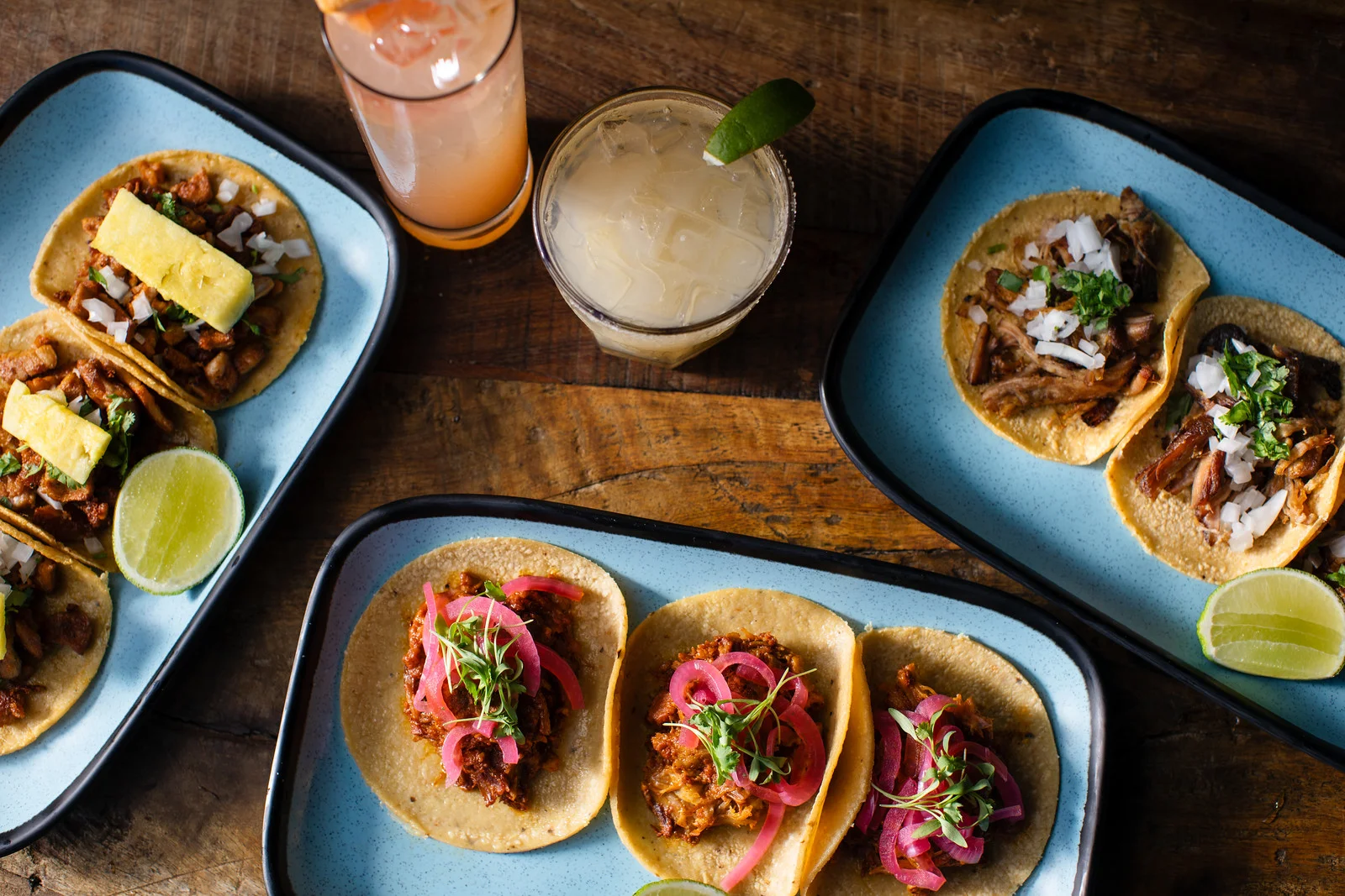 Assorted Mexican tacos with vibrant toppings and cocktails