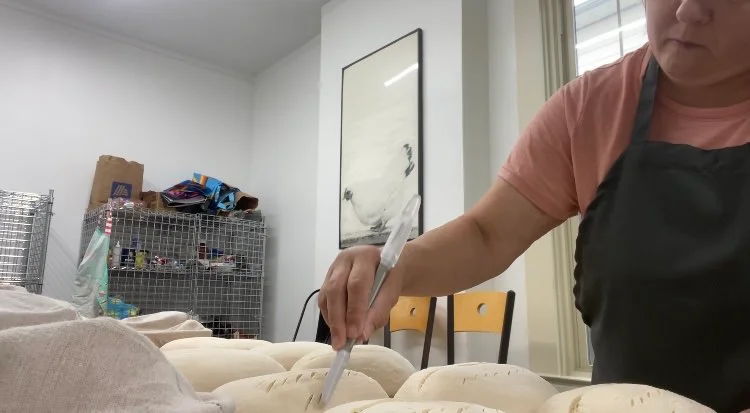 Baker scoring dough for artisan bread preparation