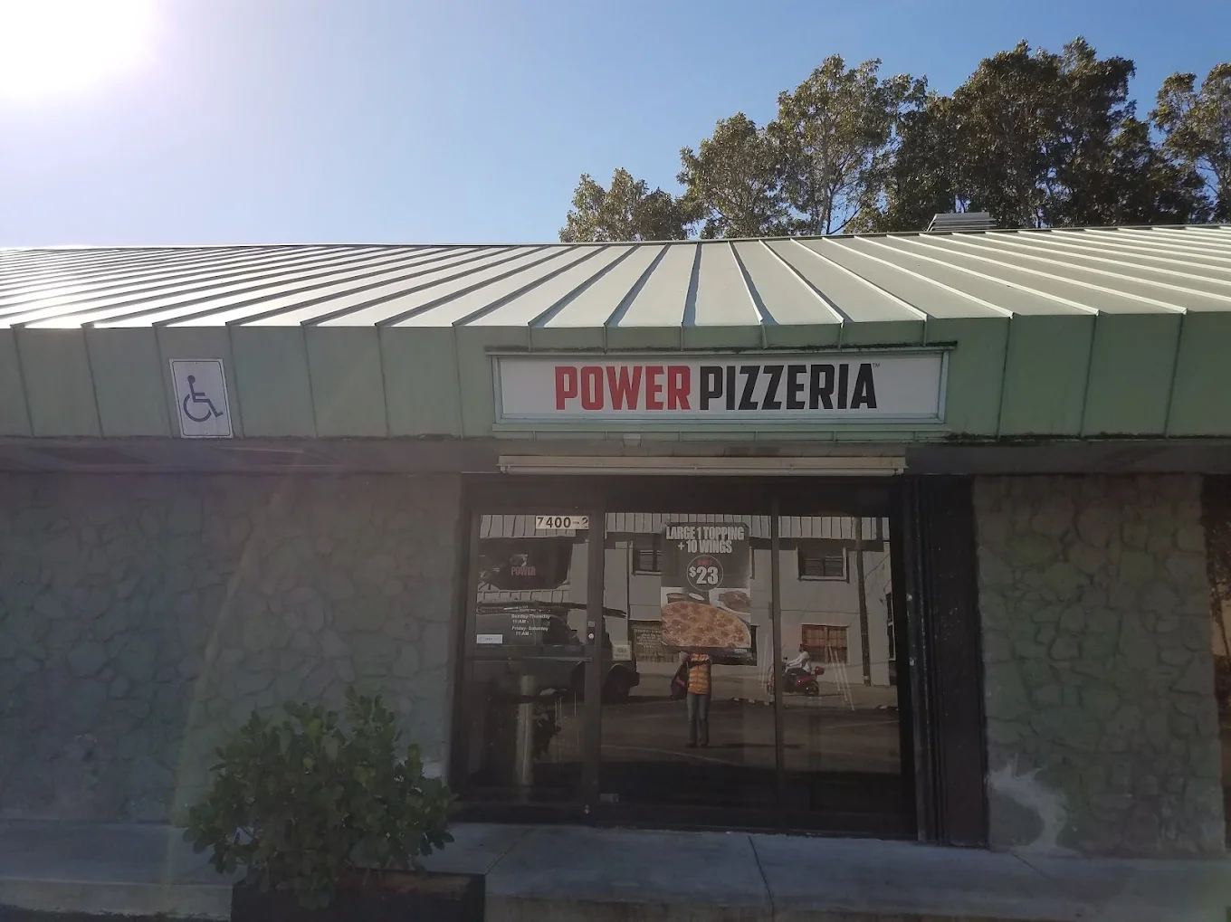 Exterior view of Power Pizzeria with signage and accessibility features