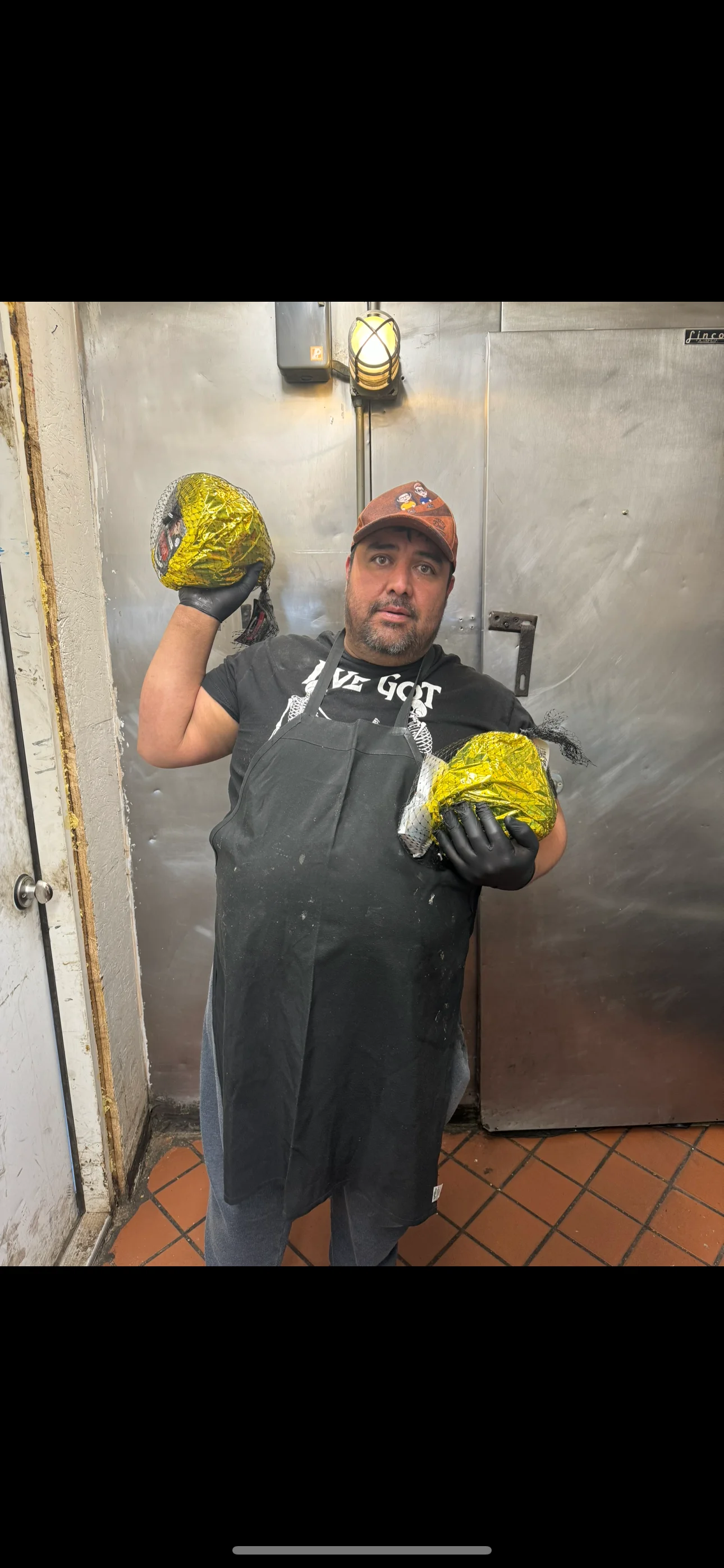 Chef showcasing wrapped tacos in a restaurant kitchen