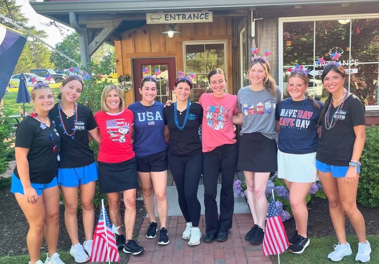 Staff celebrating at a restaurant entrance with festive attire and decorations