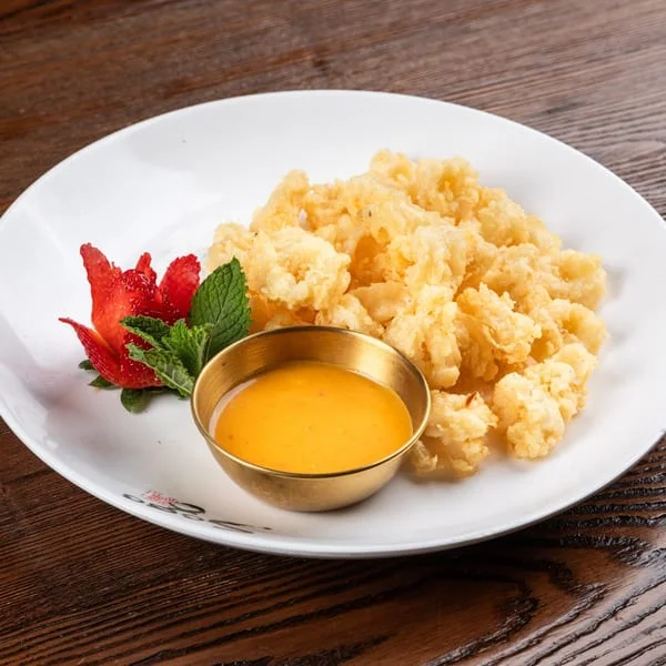 Crispy Thai calamari served with sweet chili sauce and garnished with mint and strawberry
