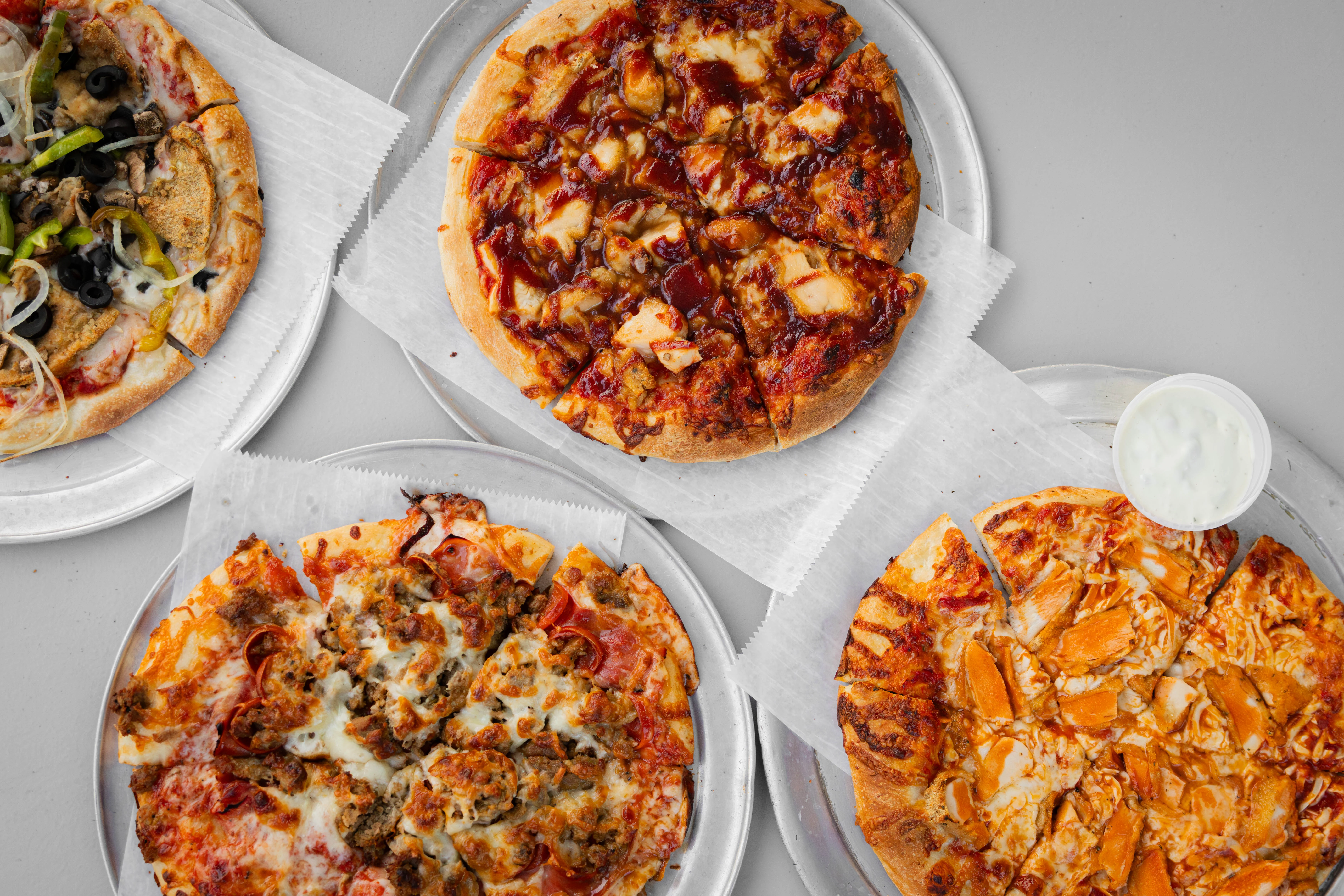 Assorted pizzas including BBQ chicken and meat lovers style