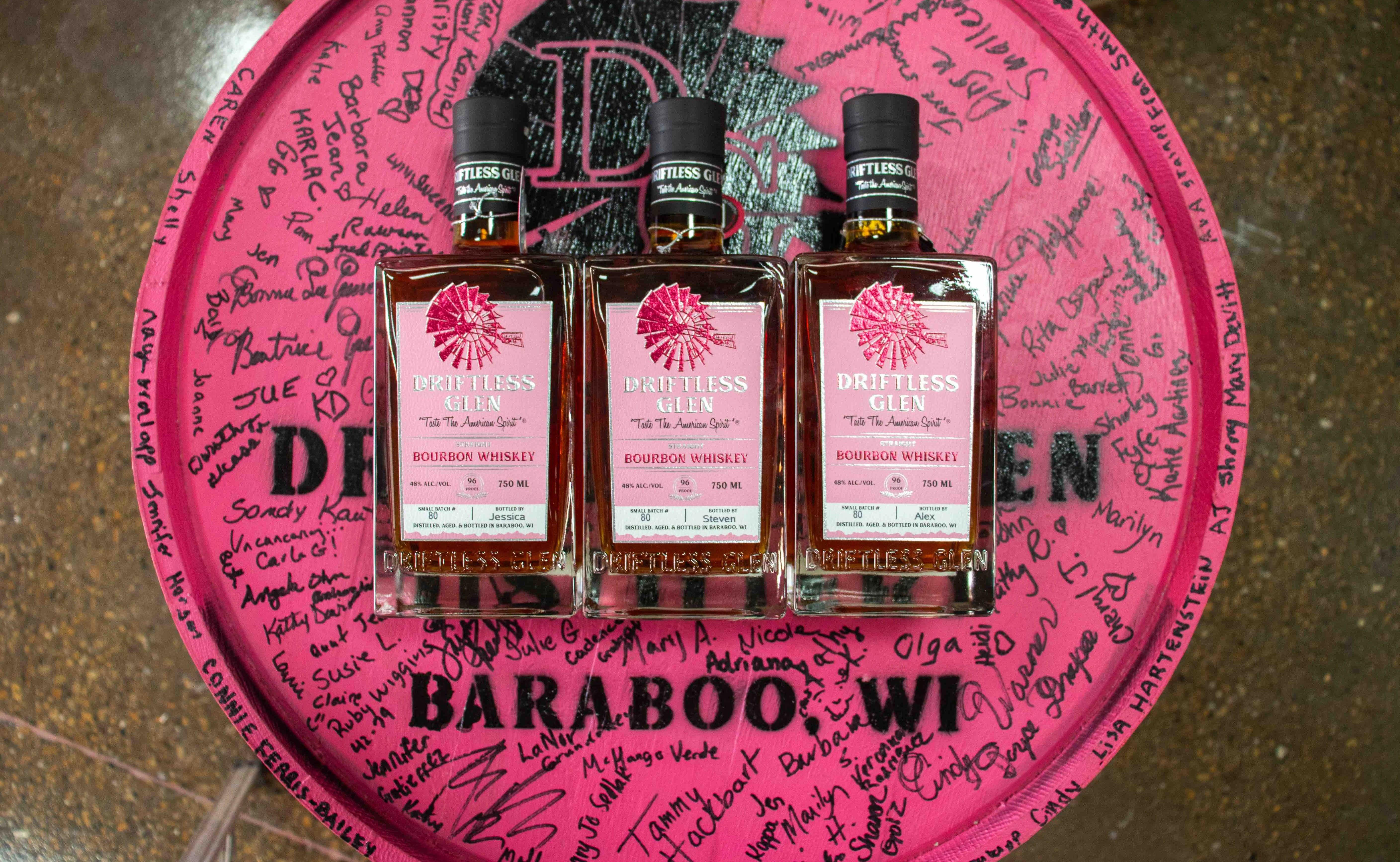 Pink label bottles of bourbon on a pink barrel.
