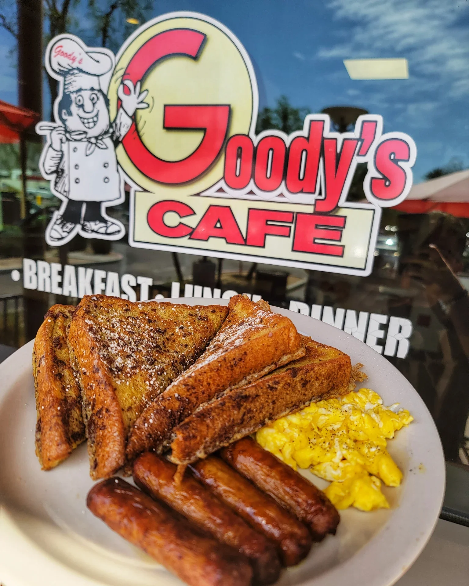 Classic American breakfast with French toast, scrambled eggs, and sausage