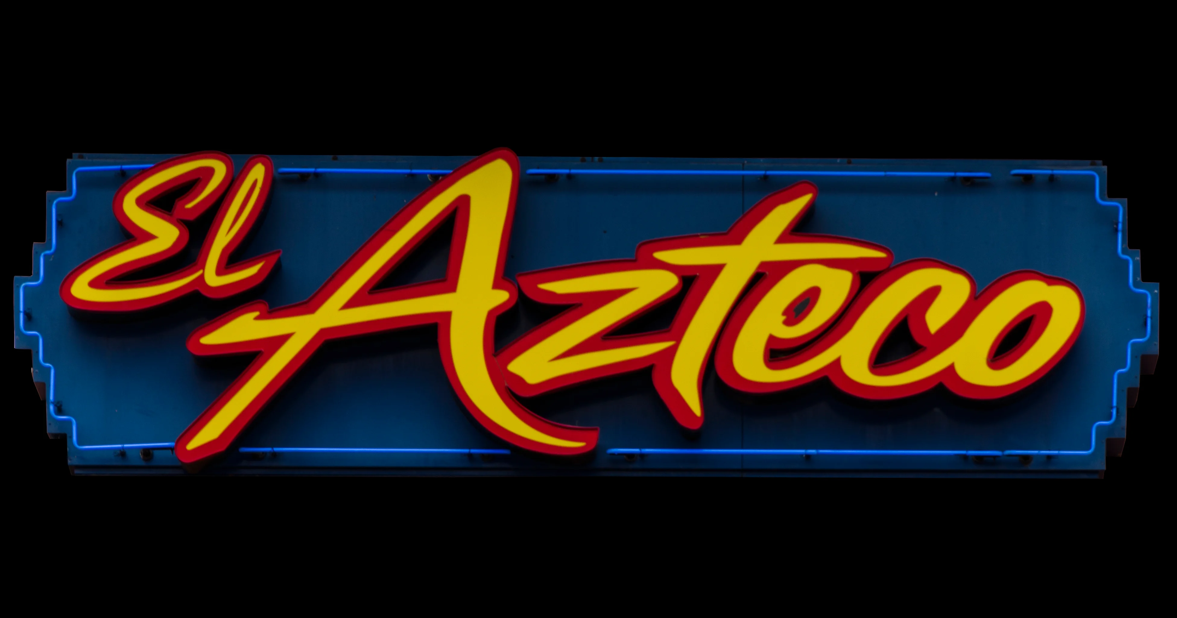 Brightly lit restaurant sign for El Azteco