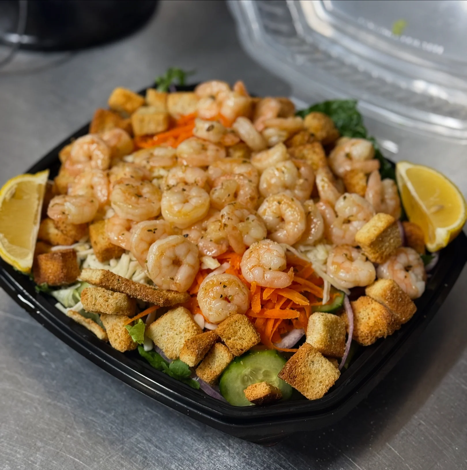 Shrimp salad with croutons and lemon wedges