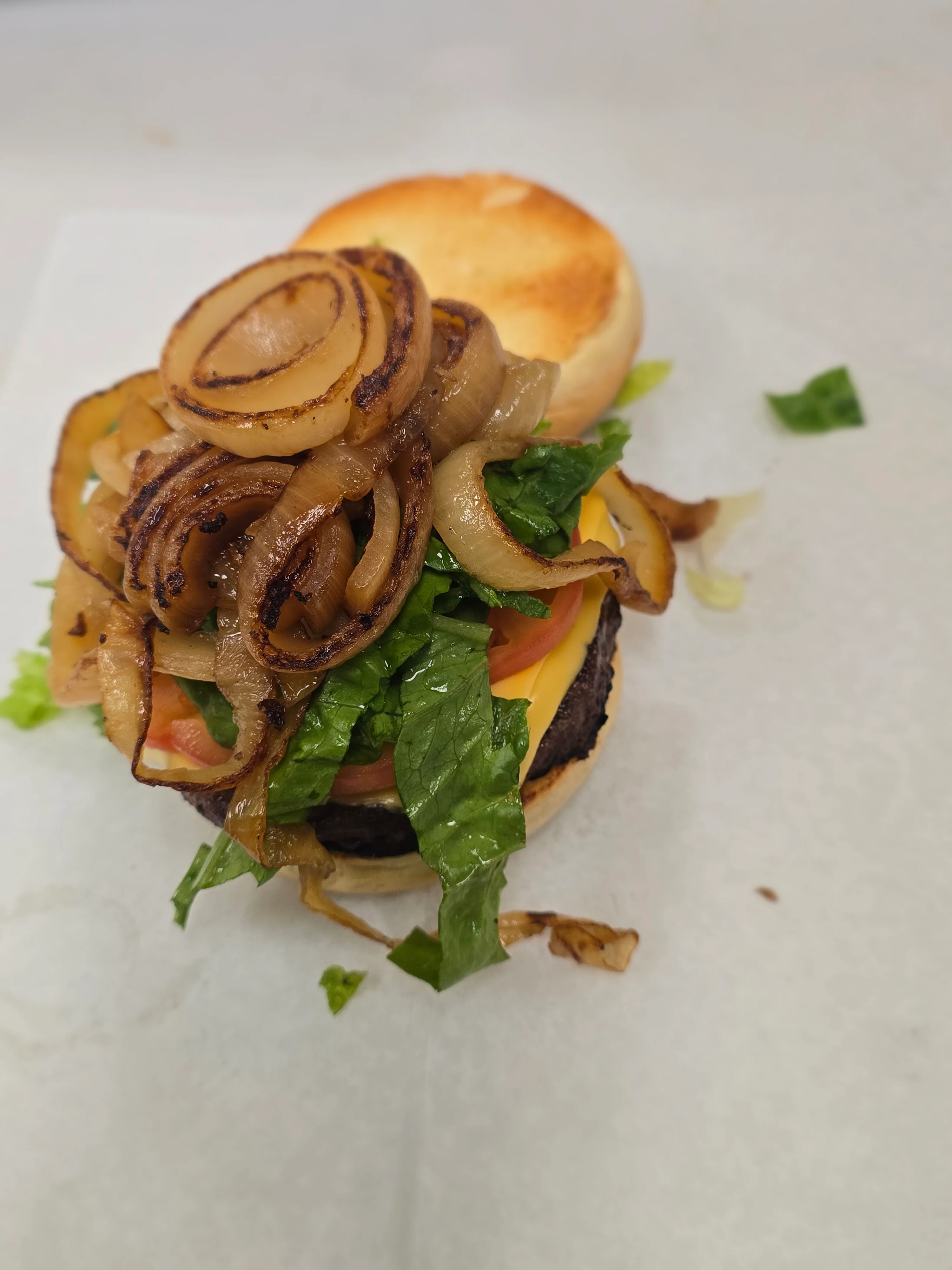 Juicy cheeseburger with grilled onions and fresh lettuce