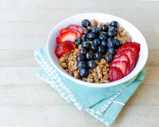 Bowl of oatmeal topped with fresh blueberries and strawberries