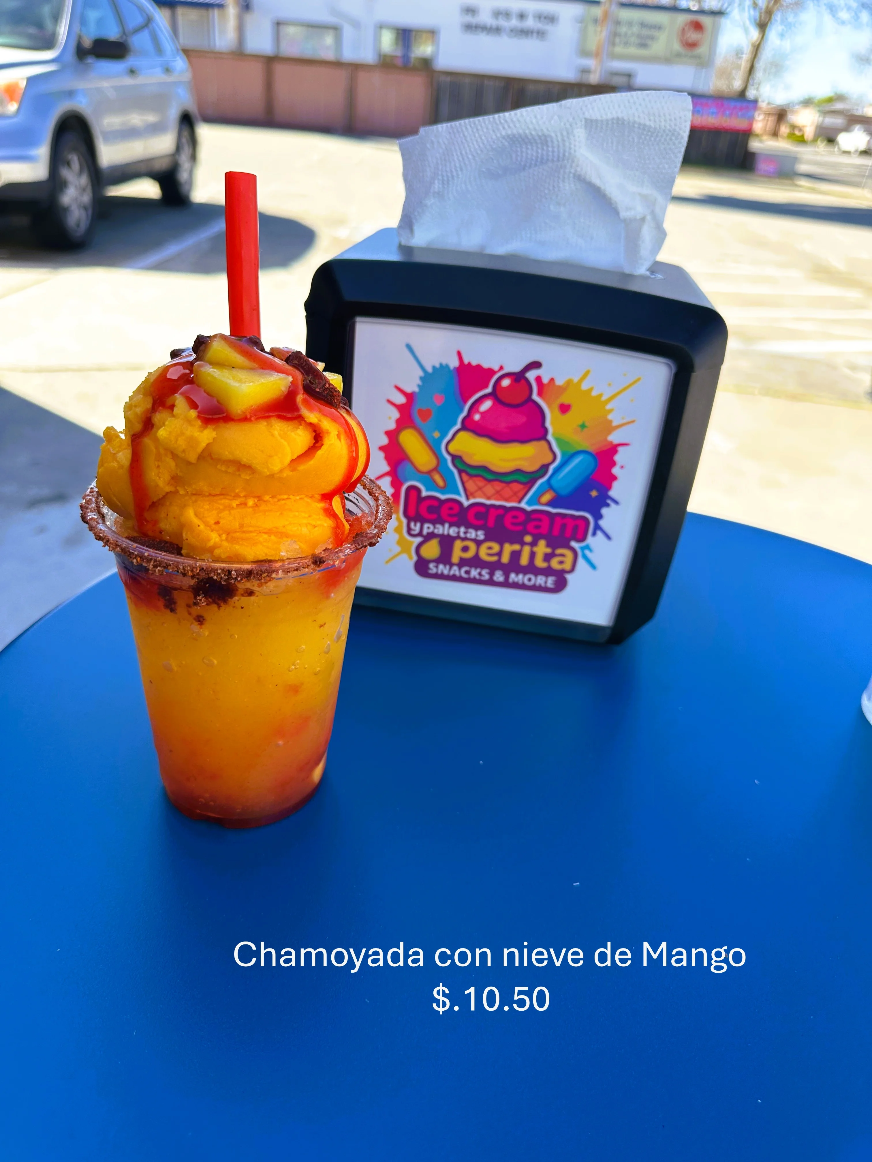 A colorful dessert featuring mango and chamoy on a snowy ice base.