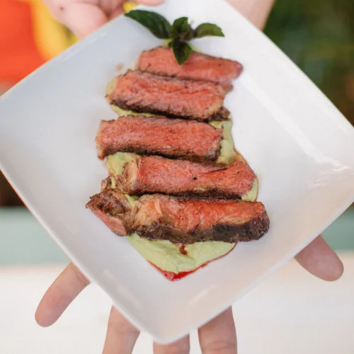 Grilled steak served on avocado puree