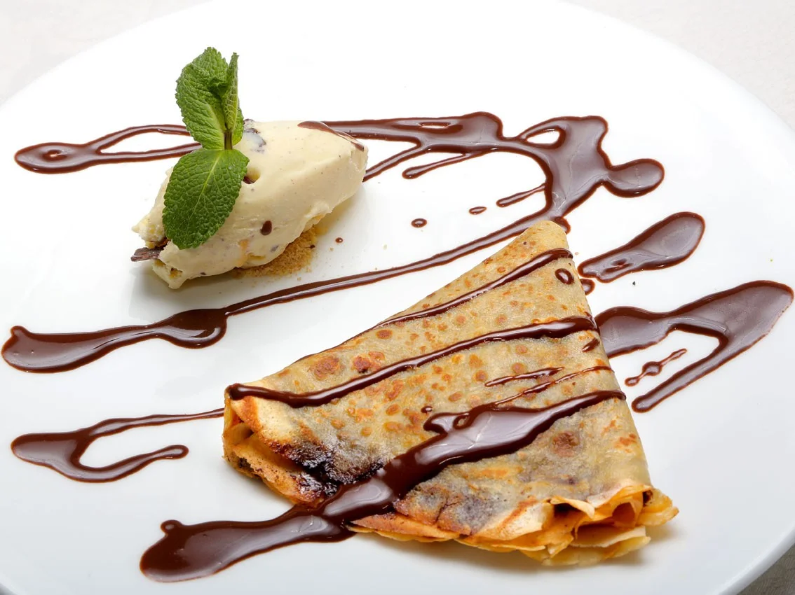 Delicious French crêpe with chocolate sauce and vanilla ice cream