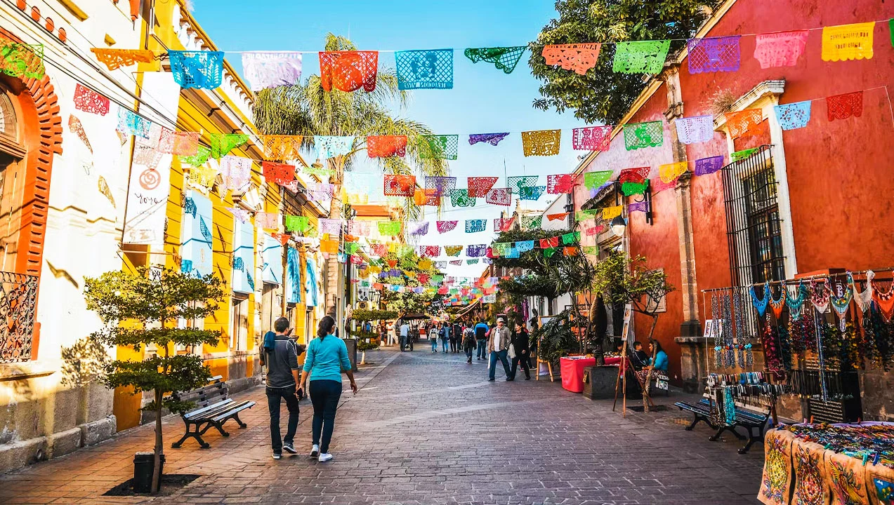 Cobblestone street of town in Mexico with color paper decorations