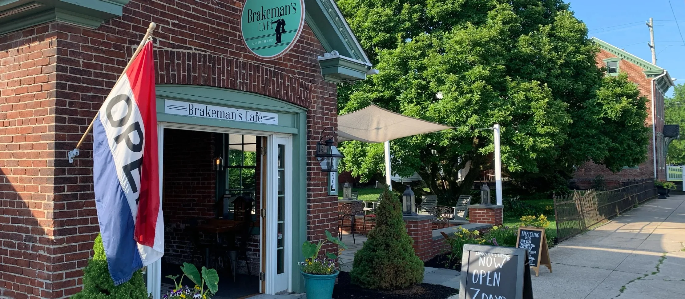 Charming café entrance with outdoor seating and open sign