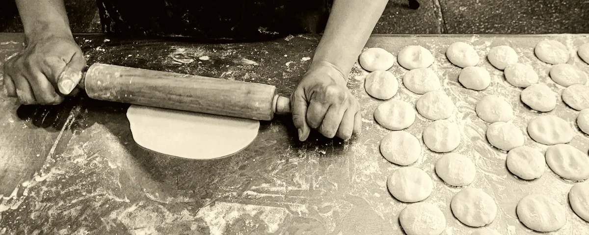 Rolling dough for traditional dumplings in a rustic kitchen