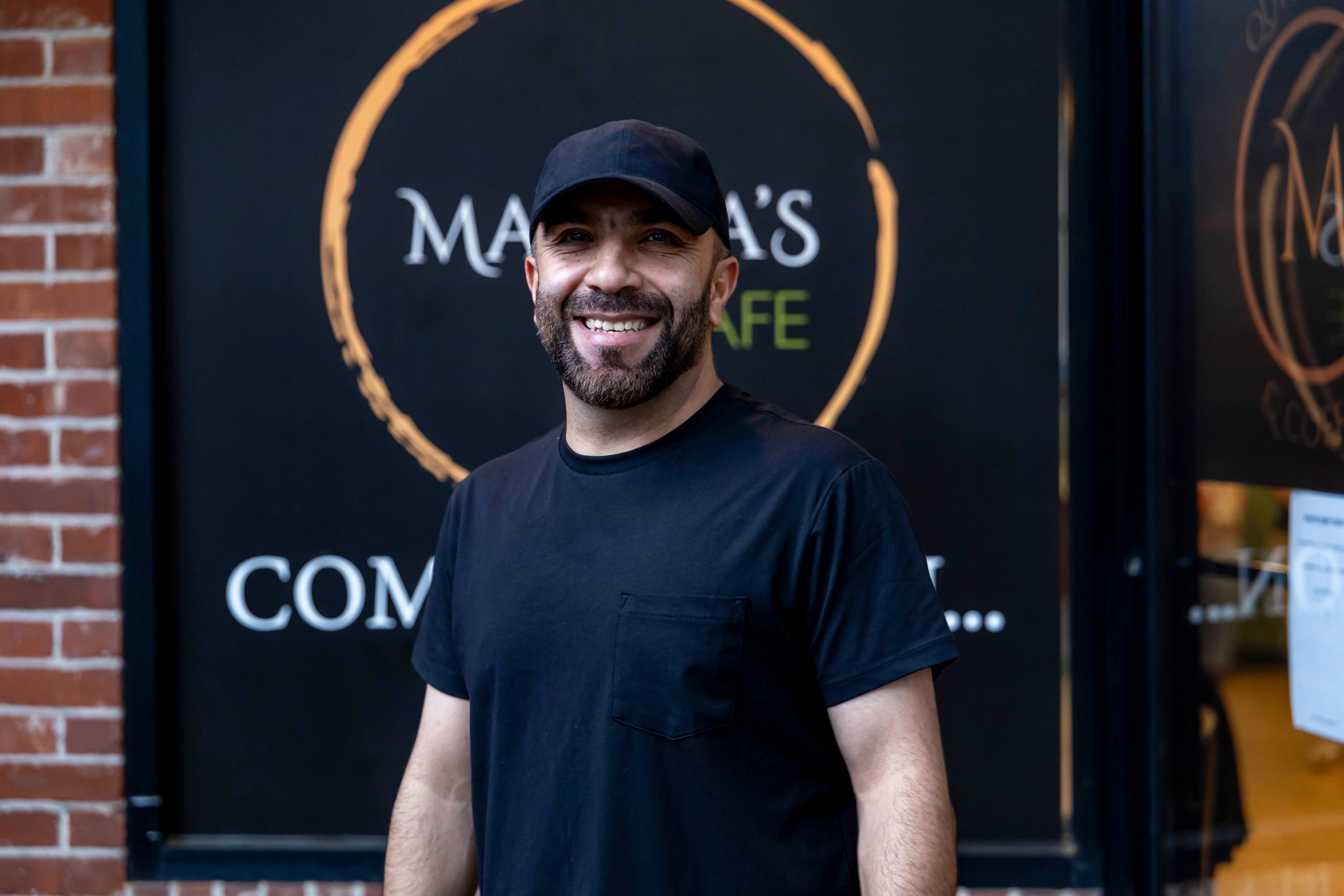 Smiling restaurant owner outside a cozy cafe