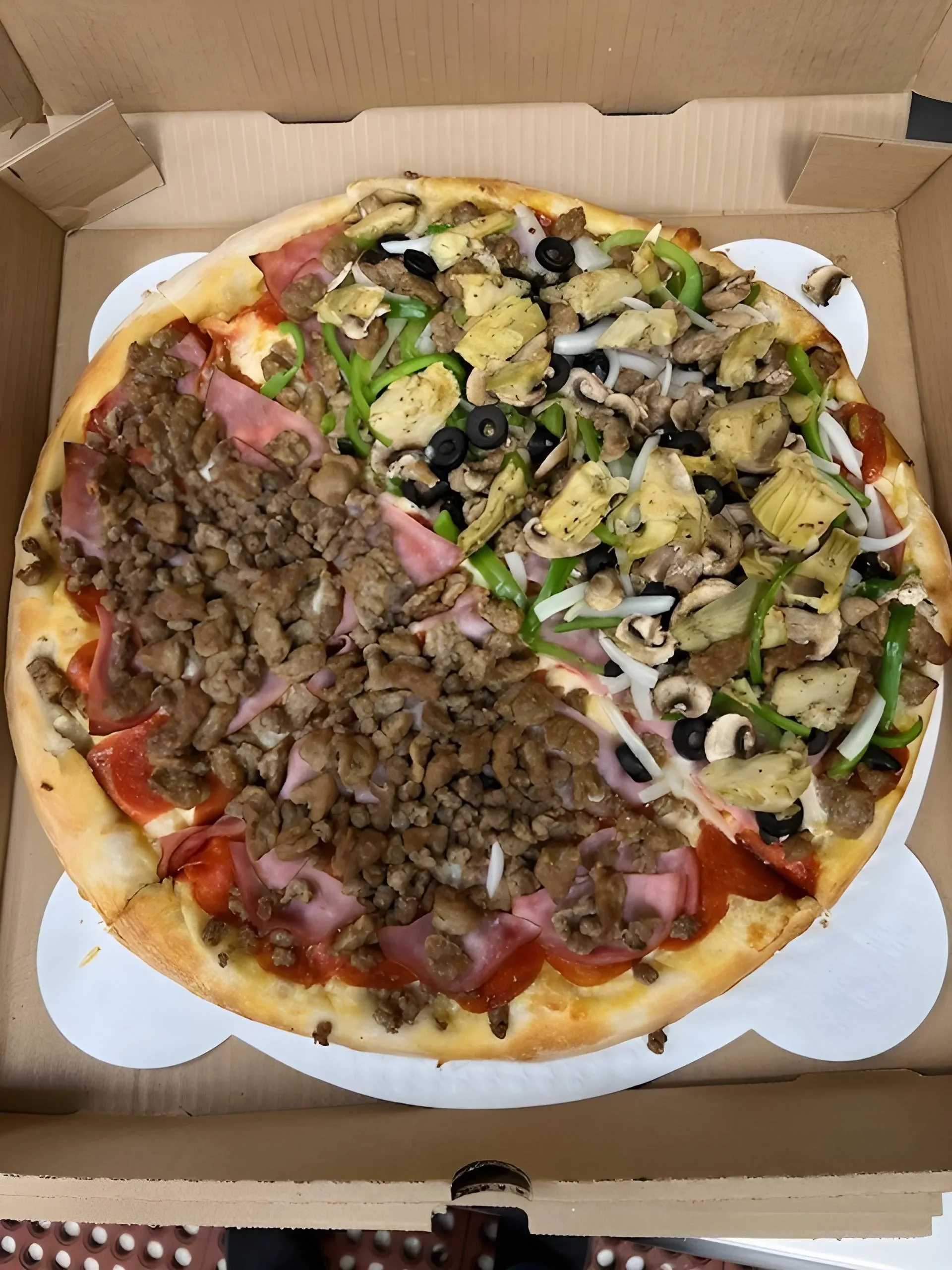 Half-and-half pizza featuring savory toppings in a takeout box