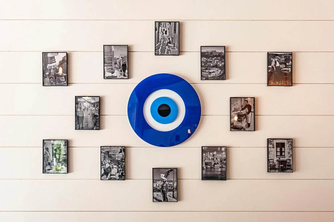 Decorative wall art featuring blue evil eye and black-and-white photos