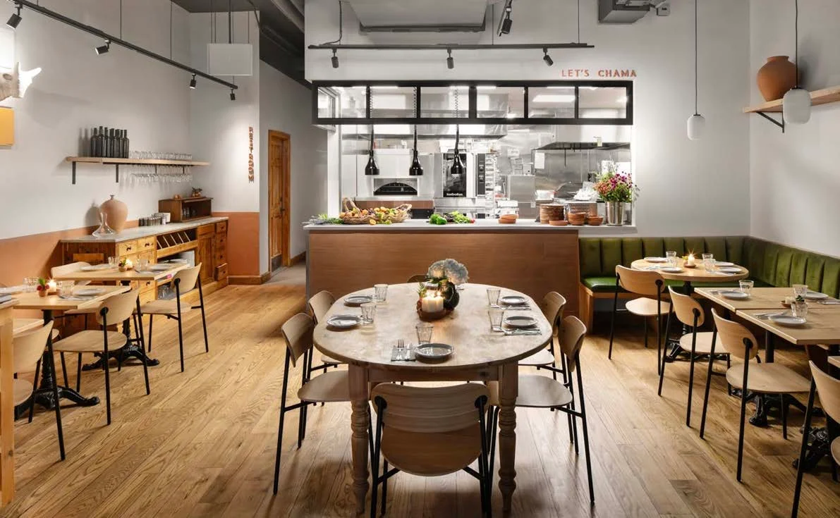 Modern restaurant interior with wooden tables and open kitchen