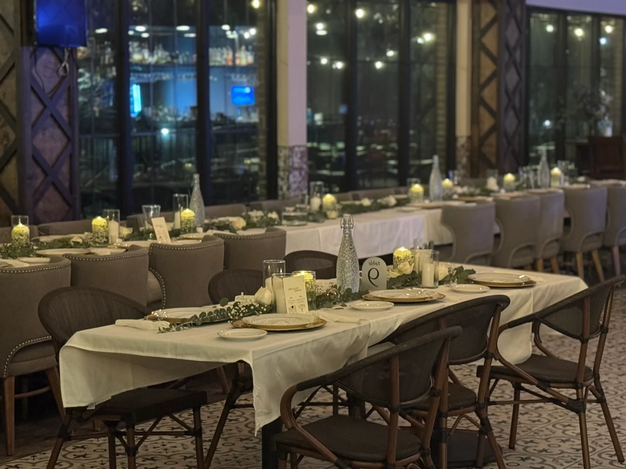 Elegant restaurant dining setup with candles and greenery