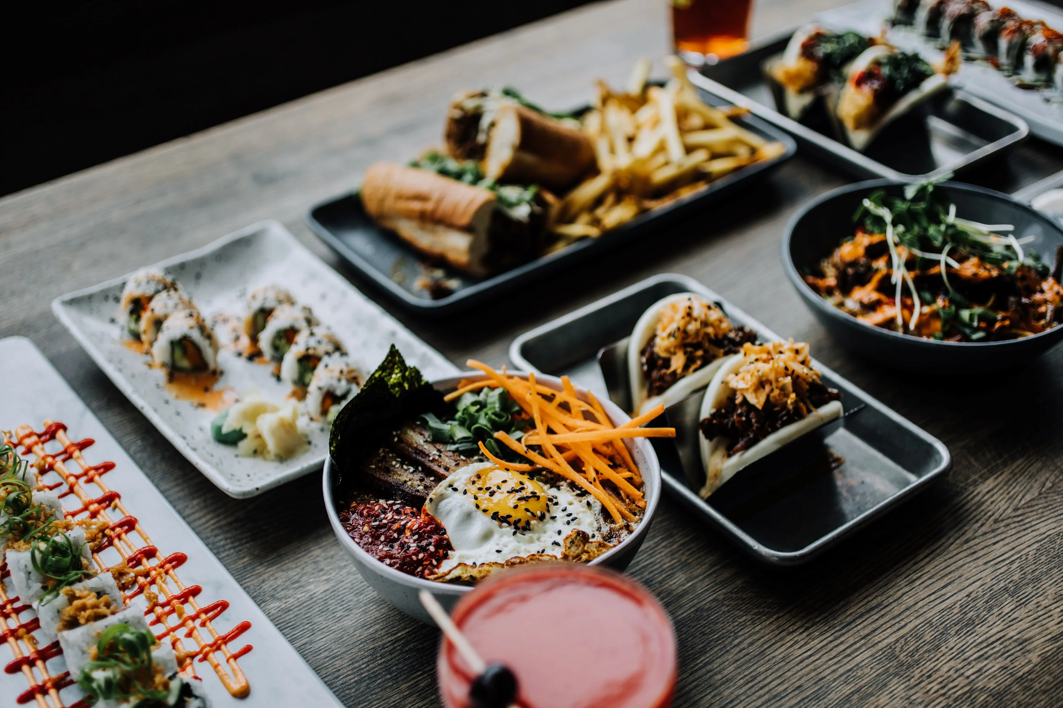Colorful Asian fusion dishes including sushi and bao buns