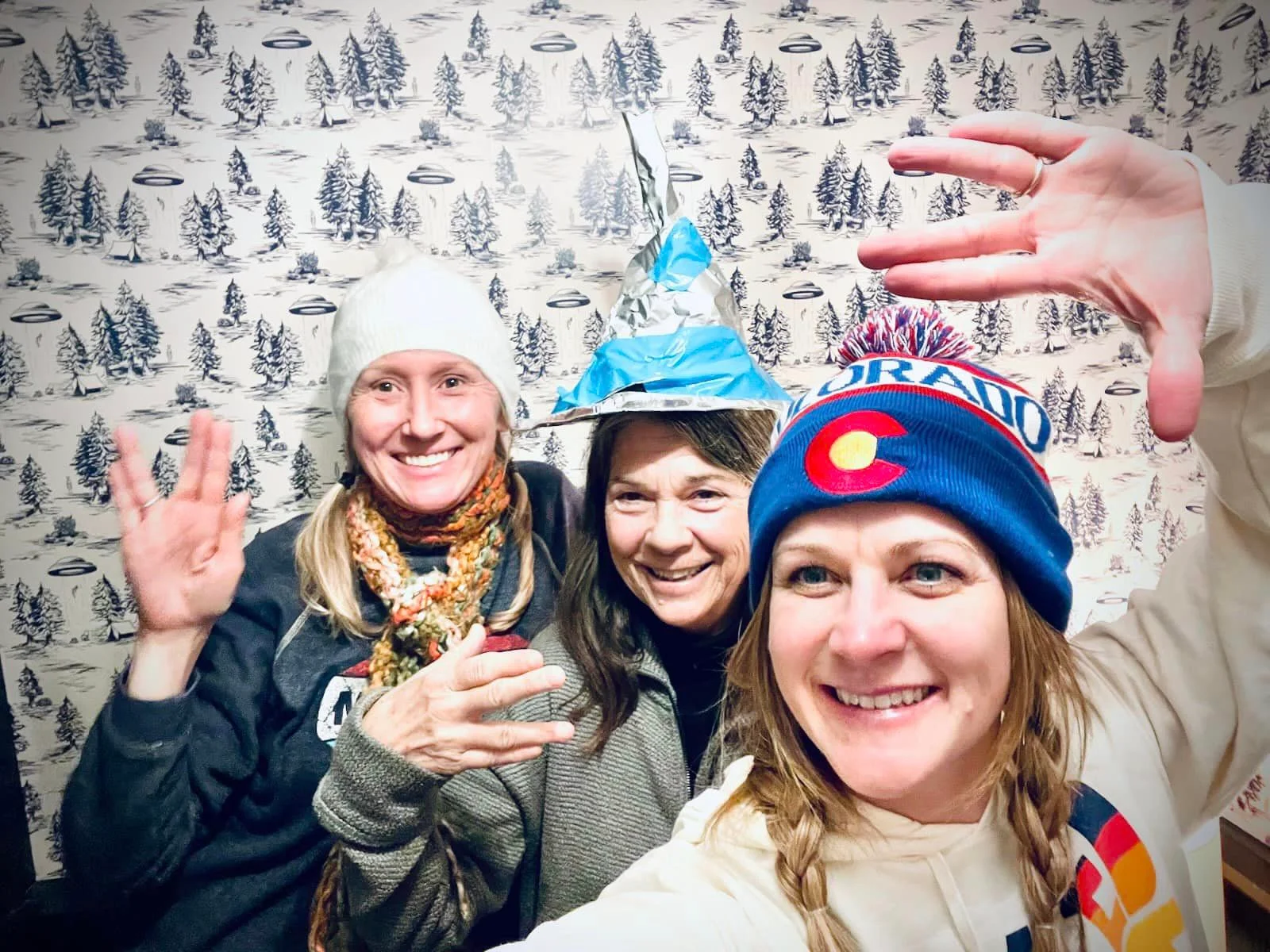 Group of friends posing with playful hats in a cozy setting