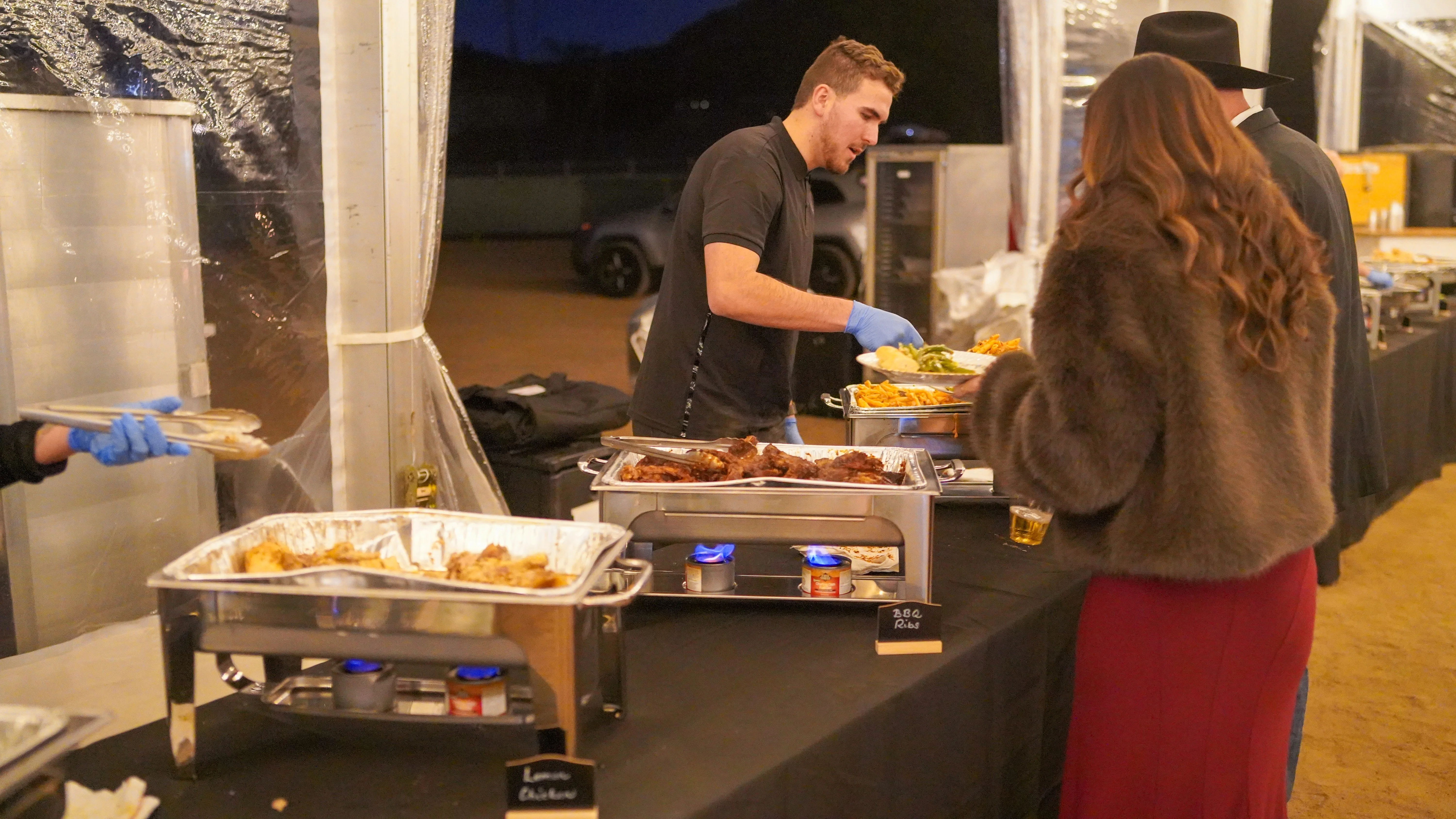 Catering service with BBQ ribs and sides at an outdoor event