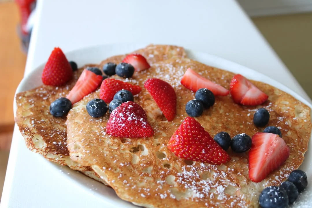 Fluffy pancakes topped with fresh strawberries and blueberries
