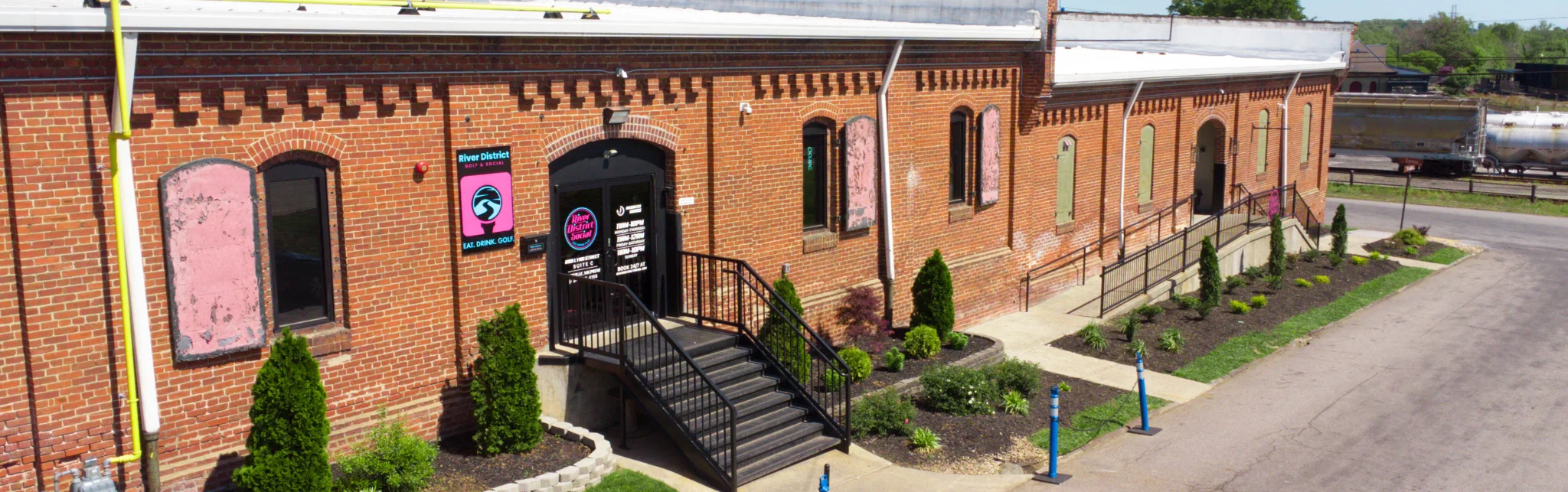 Exterior view of River District Golf & Social with brick architecture