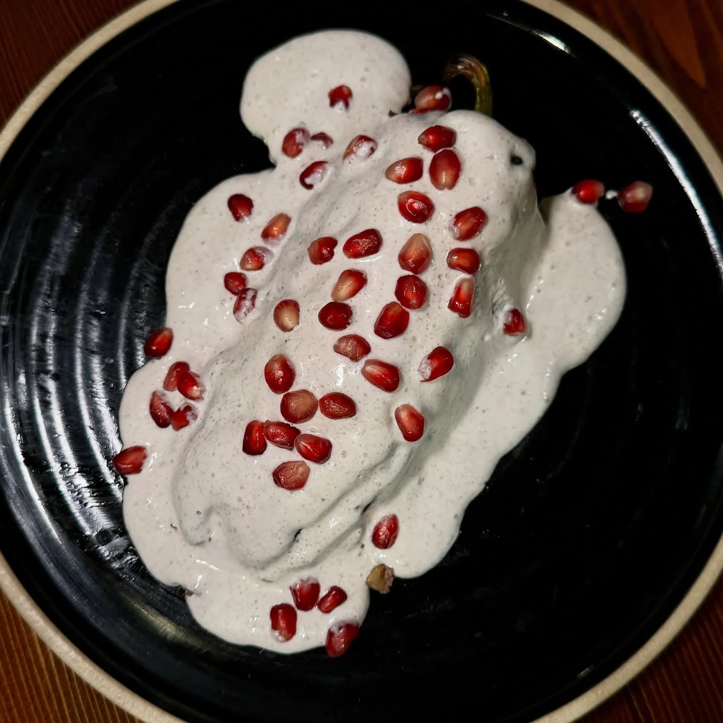 Mexican chile en nogada topped with pomegranate seeds