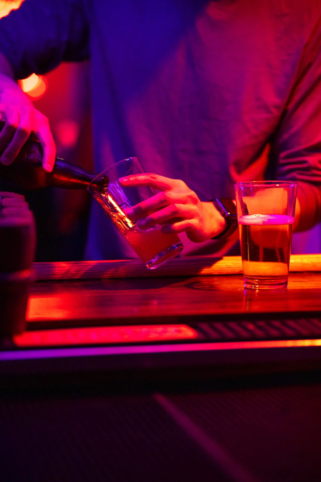 Bartender pouring beer into a glass at a vibrant bar