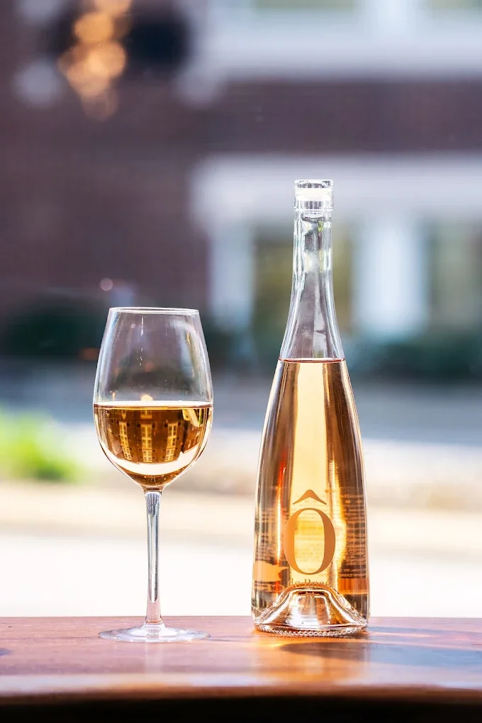 Chilled bottle of rosé wine with a glass on a wooden table