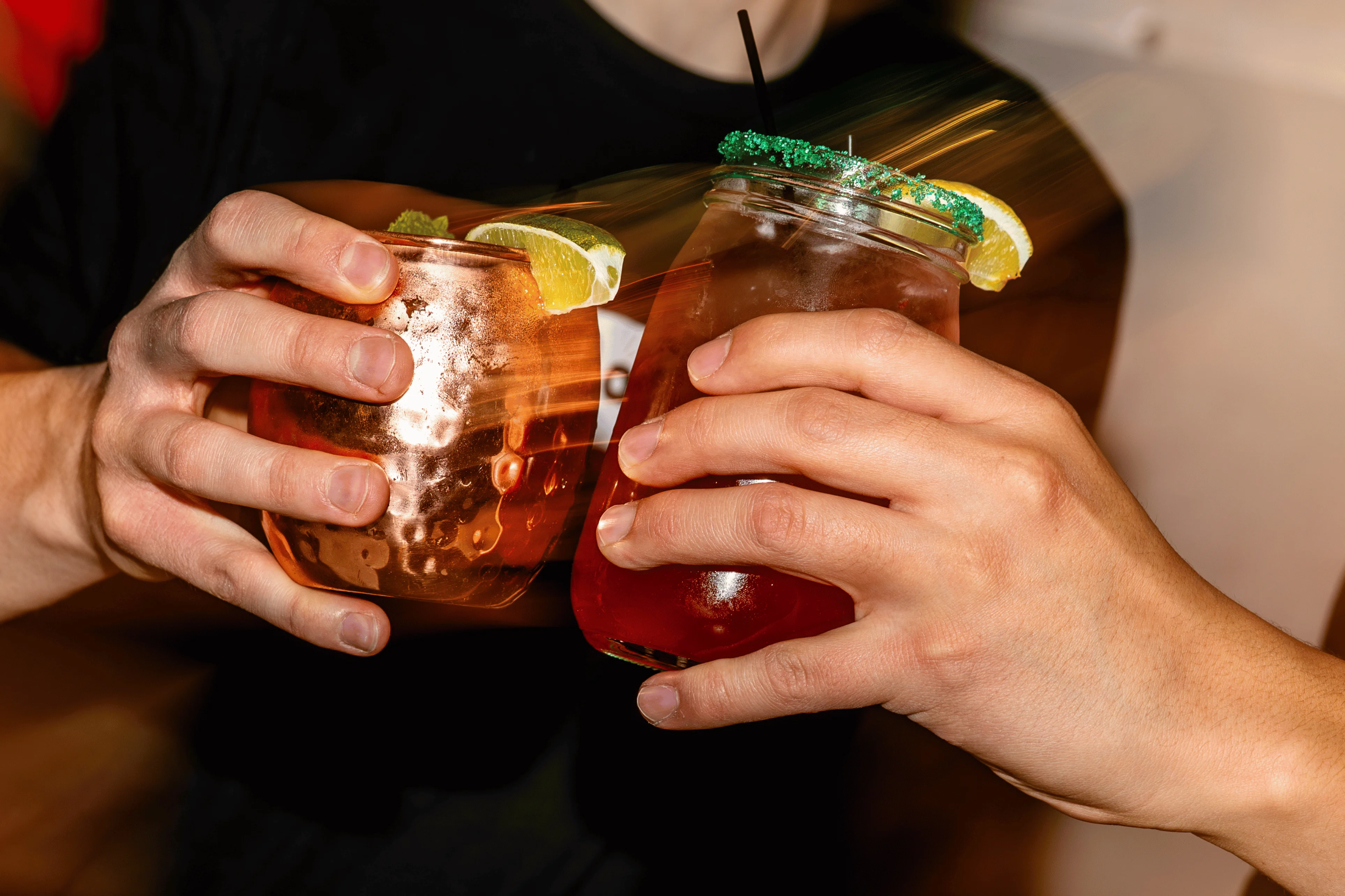Two cocktails clinking together in celebration