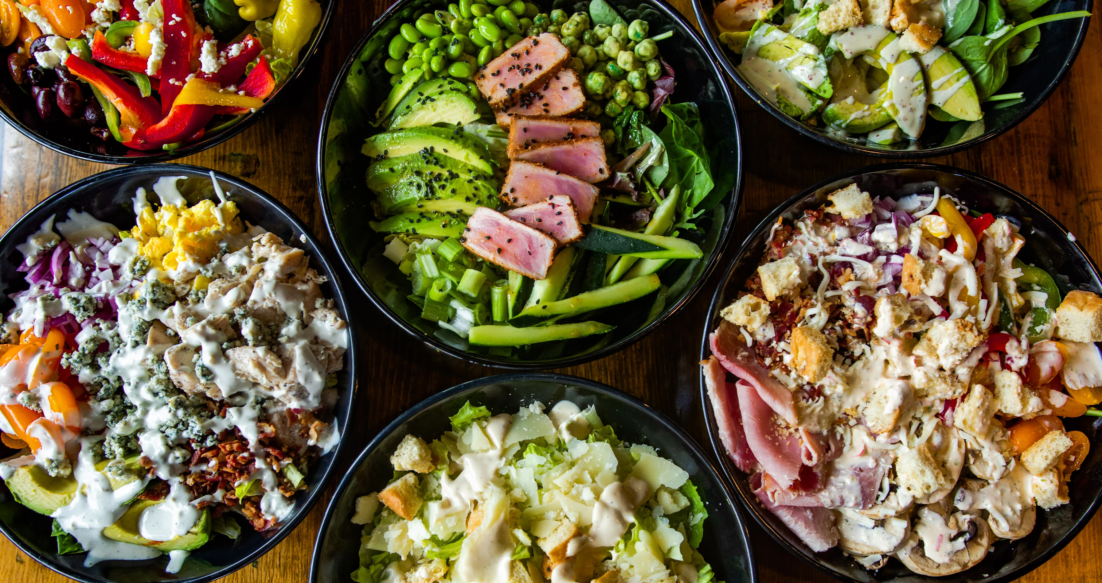 Assorted gourmet salads in black bowls