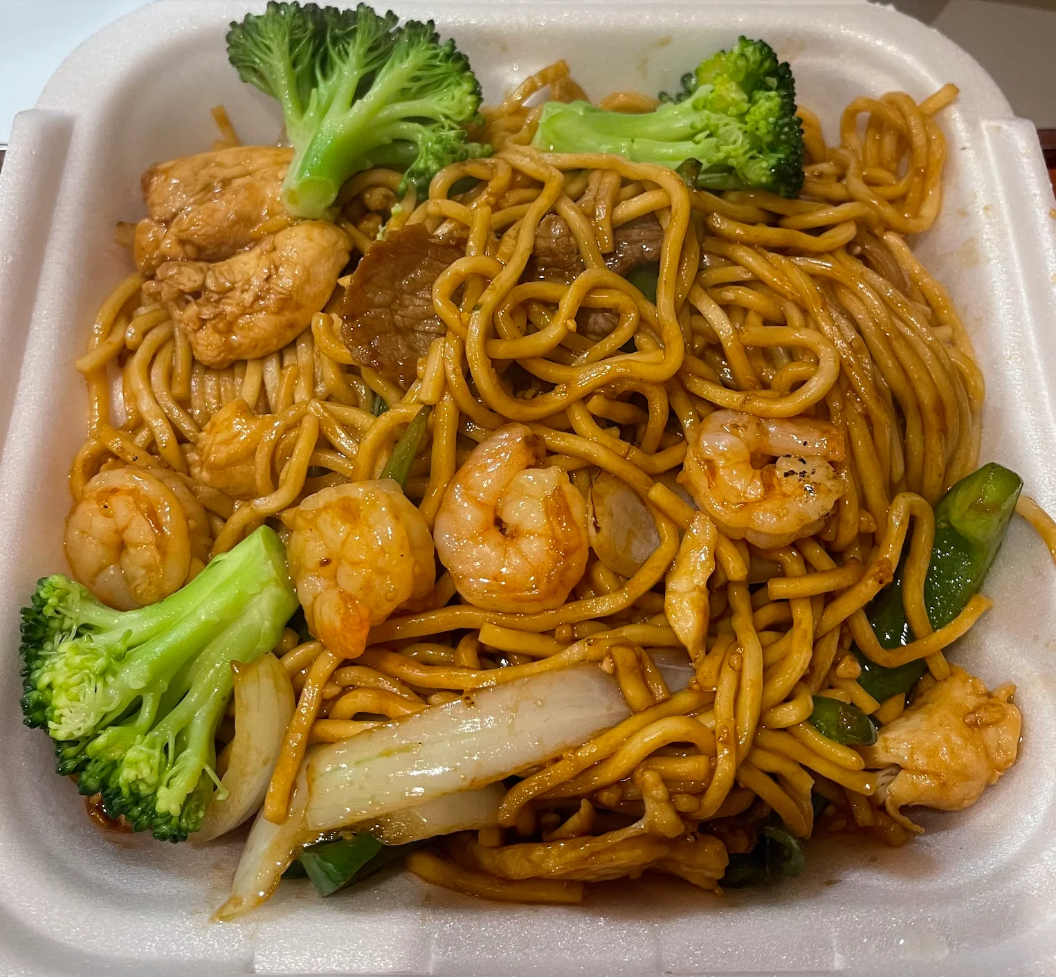 Shrimp lo mein with vegetables in a takeout container