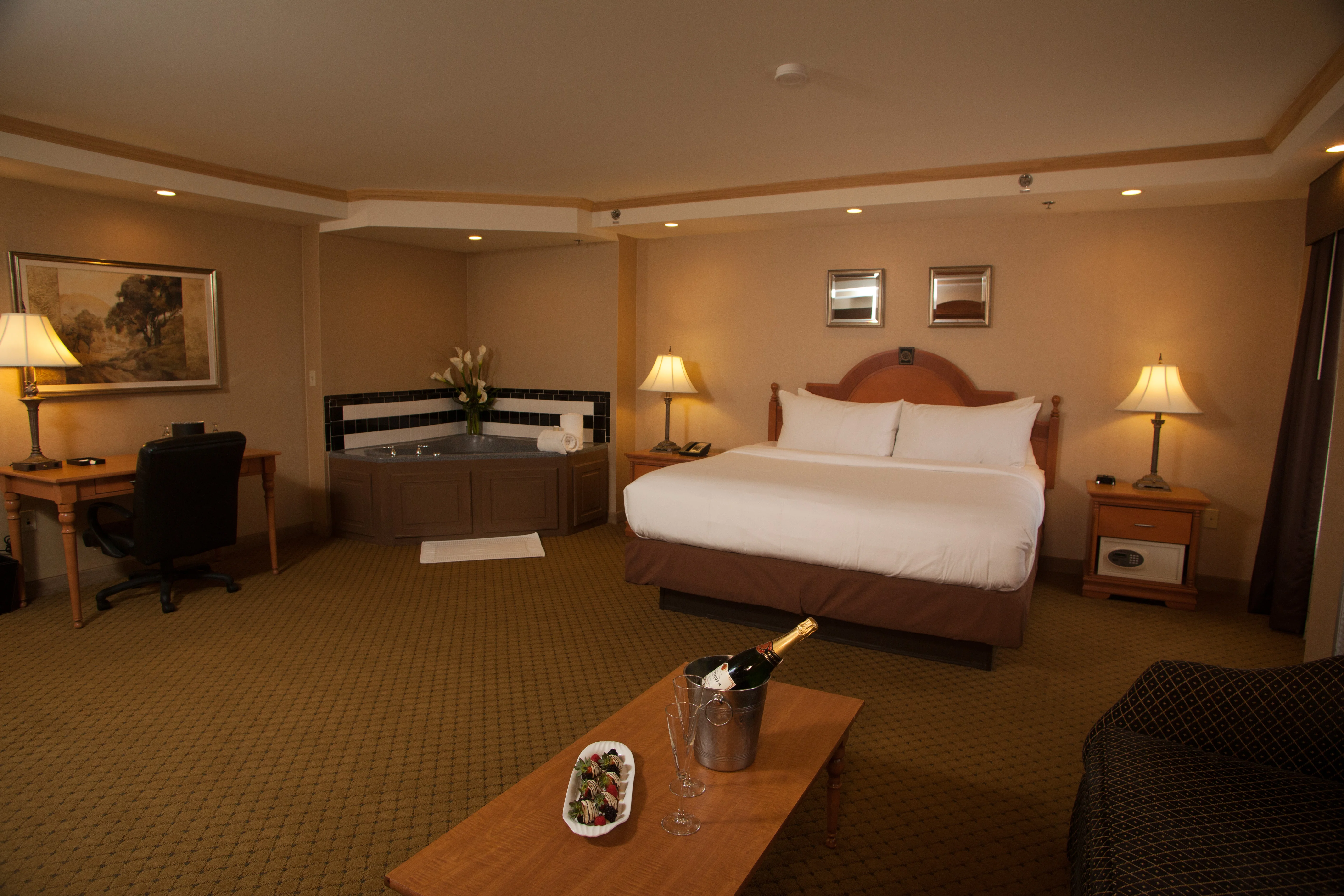King whirlpool suite at the Ambassador Hotel with a king bed, two person whirlpool tub a couch and coffee table