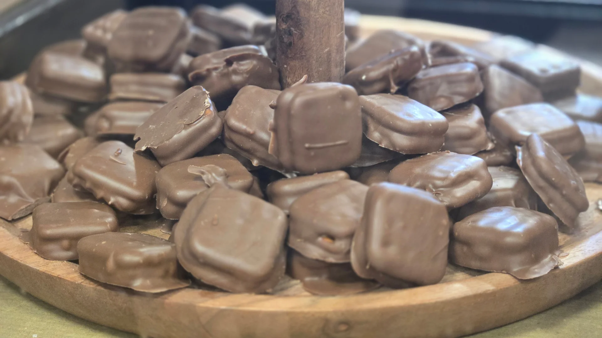 Assorted chocolate-covered confections on a wooden platter