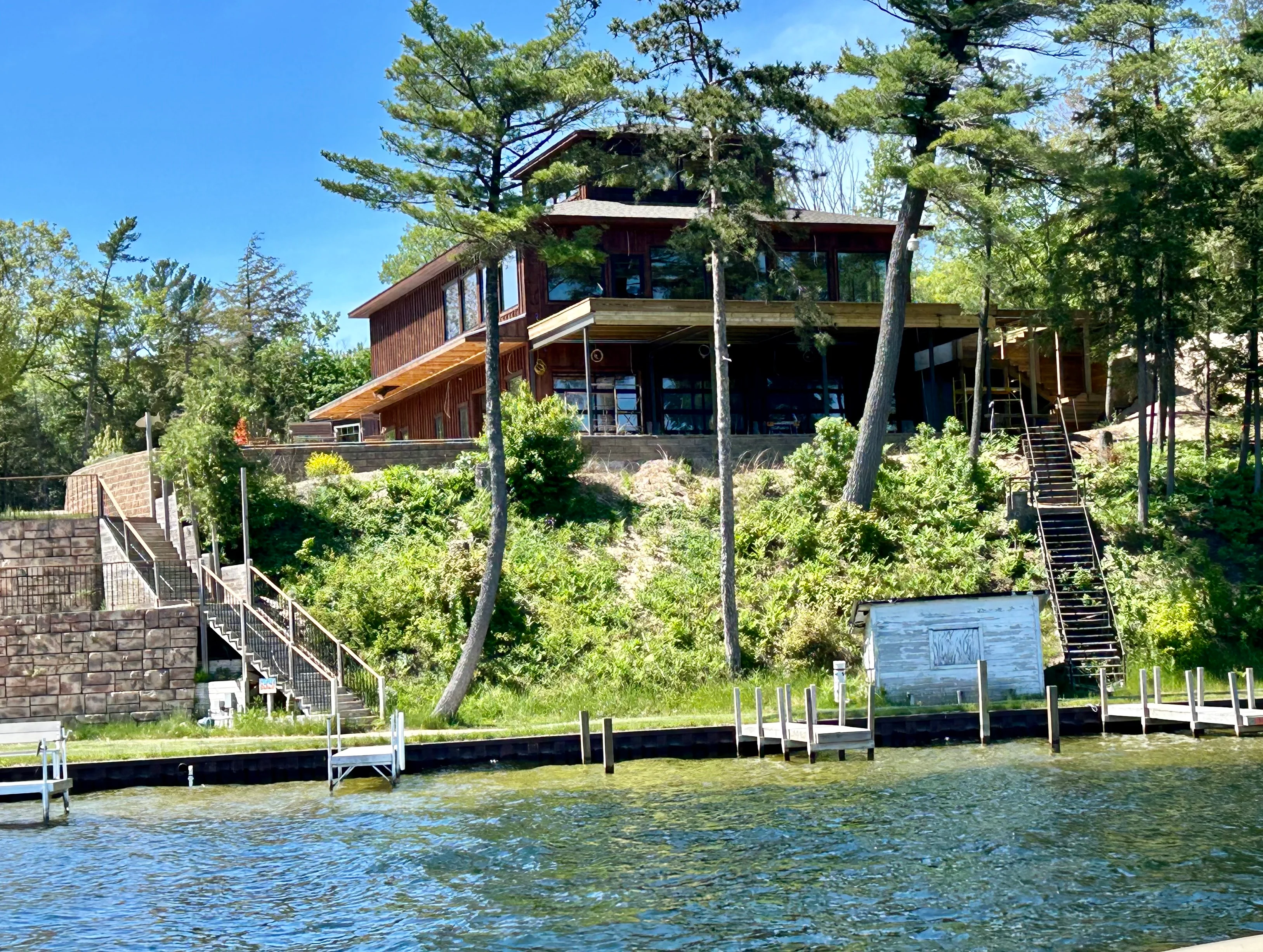 Modern lakeside house with wooden architecture and lush greenery