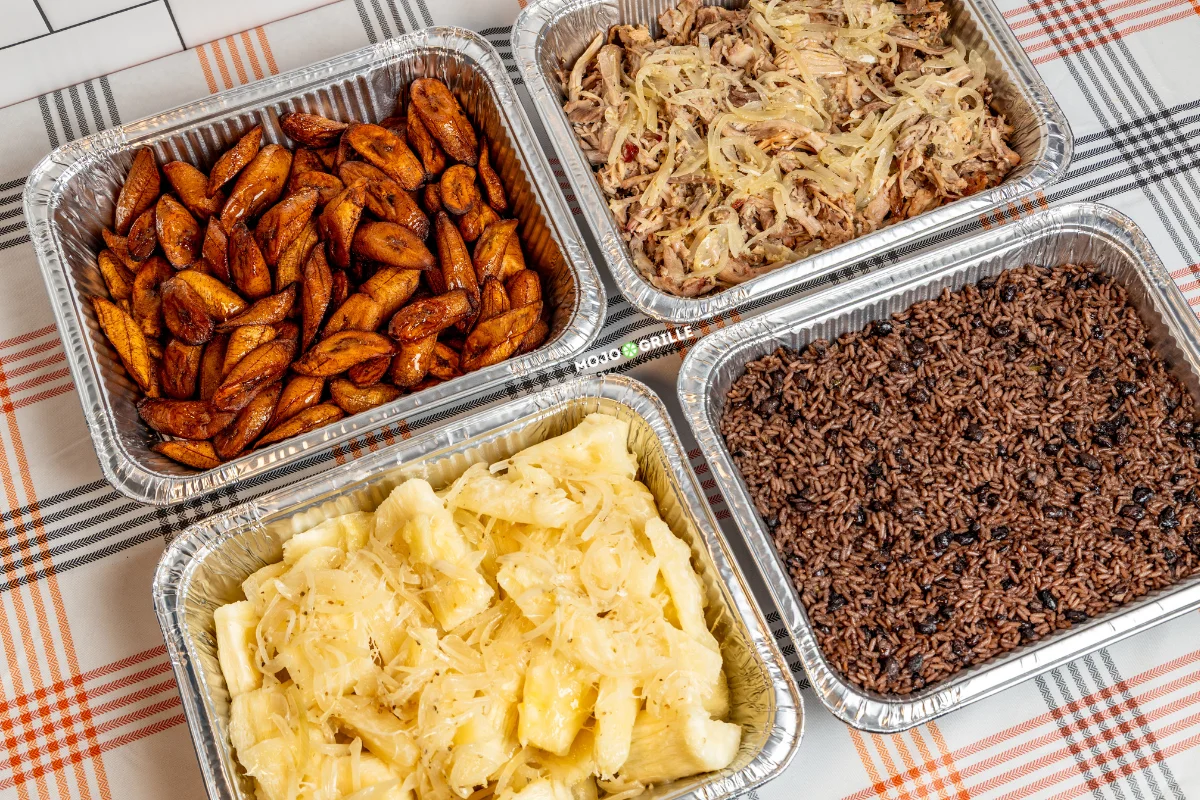 Caribbean feast featuring fried plantains, rice and beans, and pulled pork