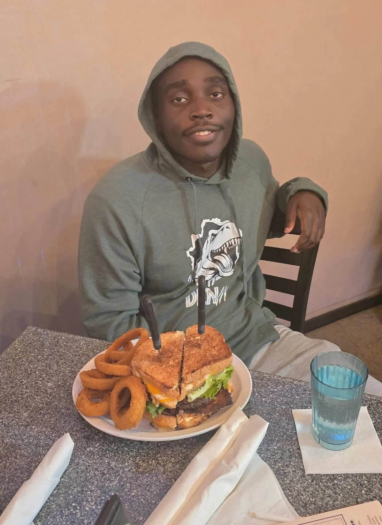 Giant cheeseburger with onion rings in a casual dining setting