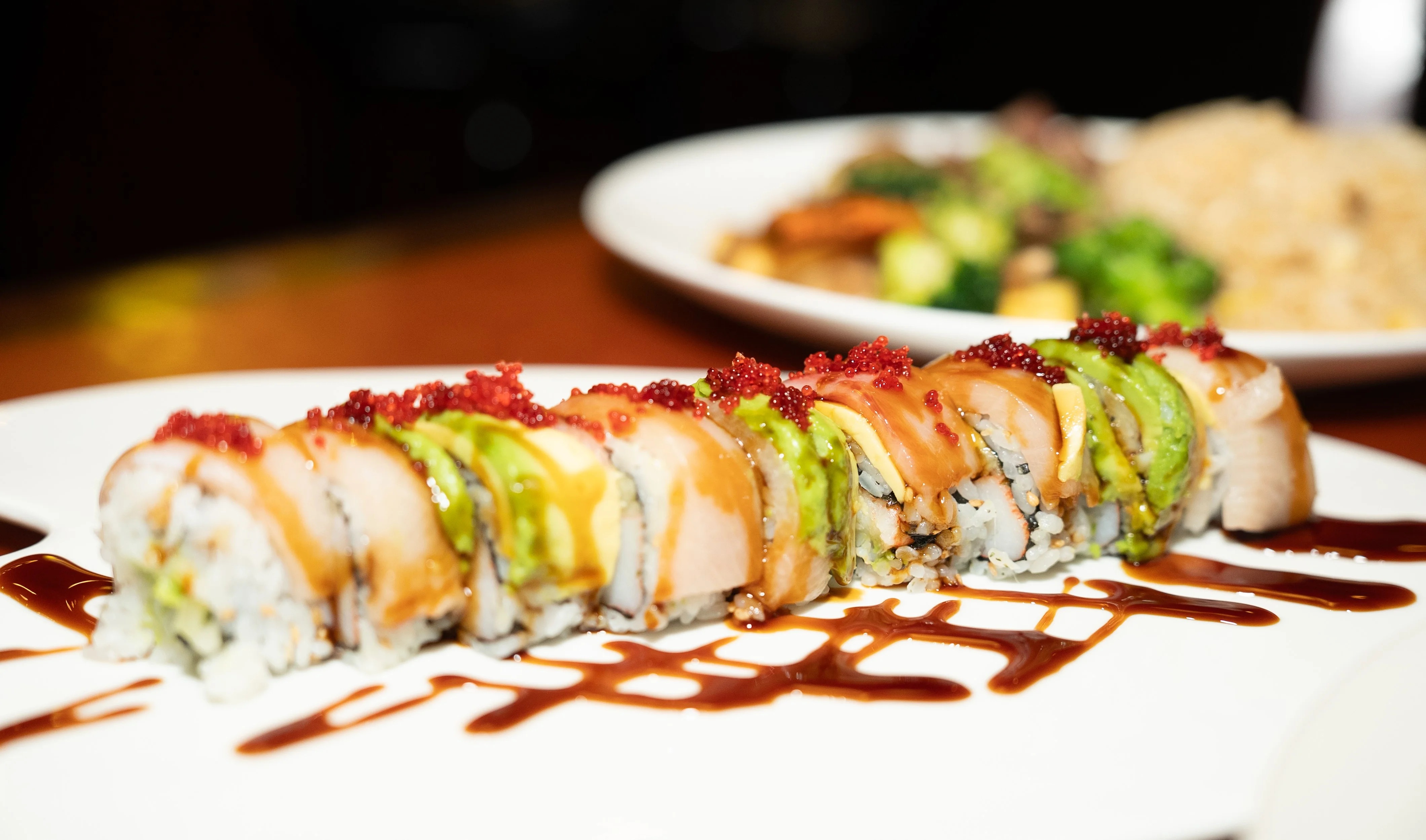 Colorful sushi roll with avocado and spicy sauce