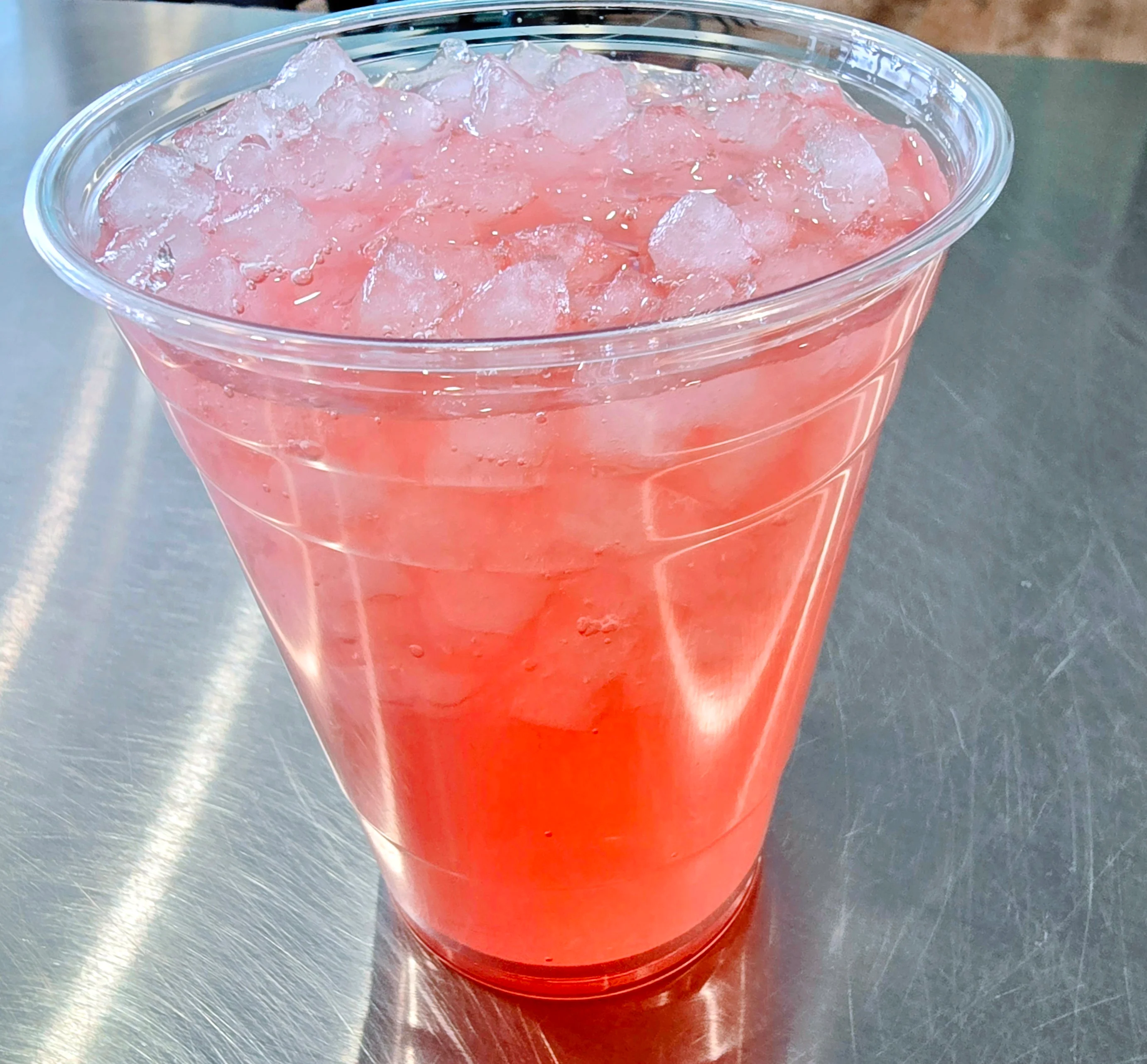 Refreshing pink lemonade in a clear cup with ice