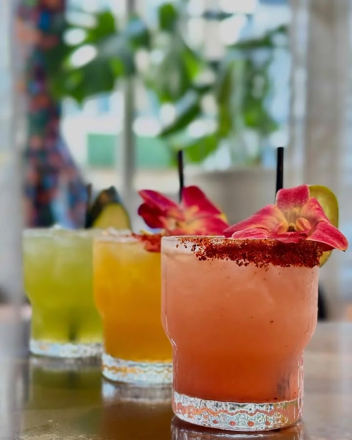 Colorful cocktails garnished with flowers at a modern bar