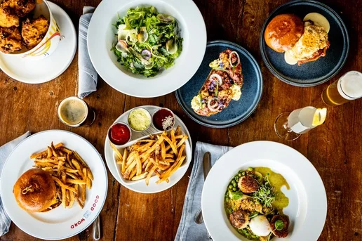 Assorted American dishes including burgers and salad on a wooden table