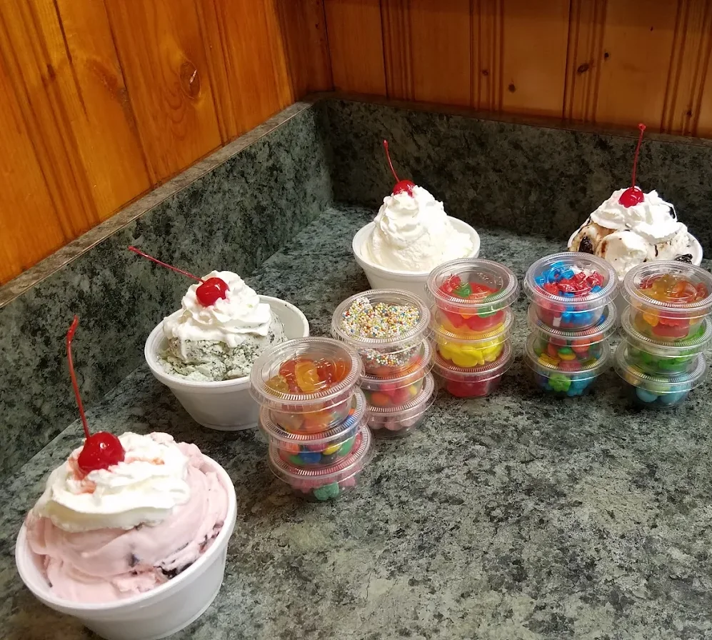 Assorted ice cream sundaes with toppings and cherries