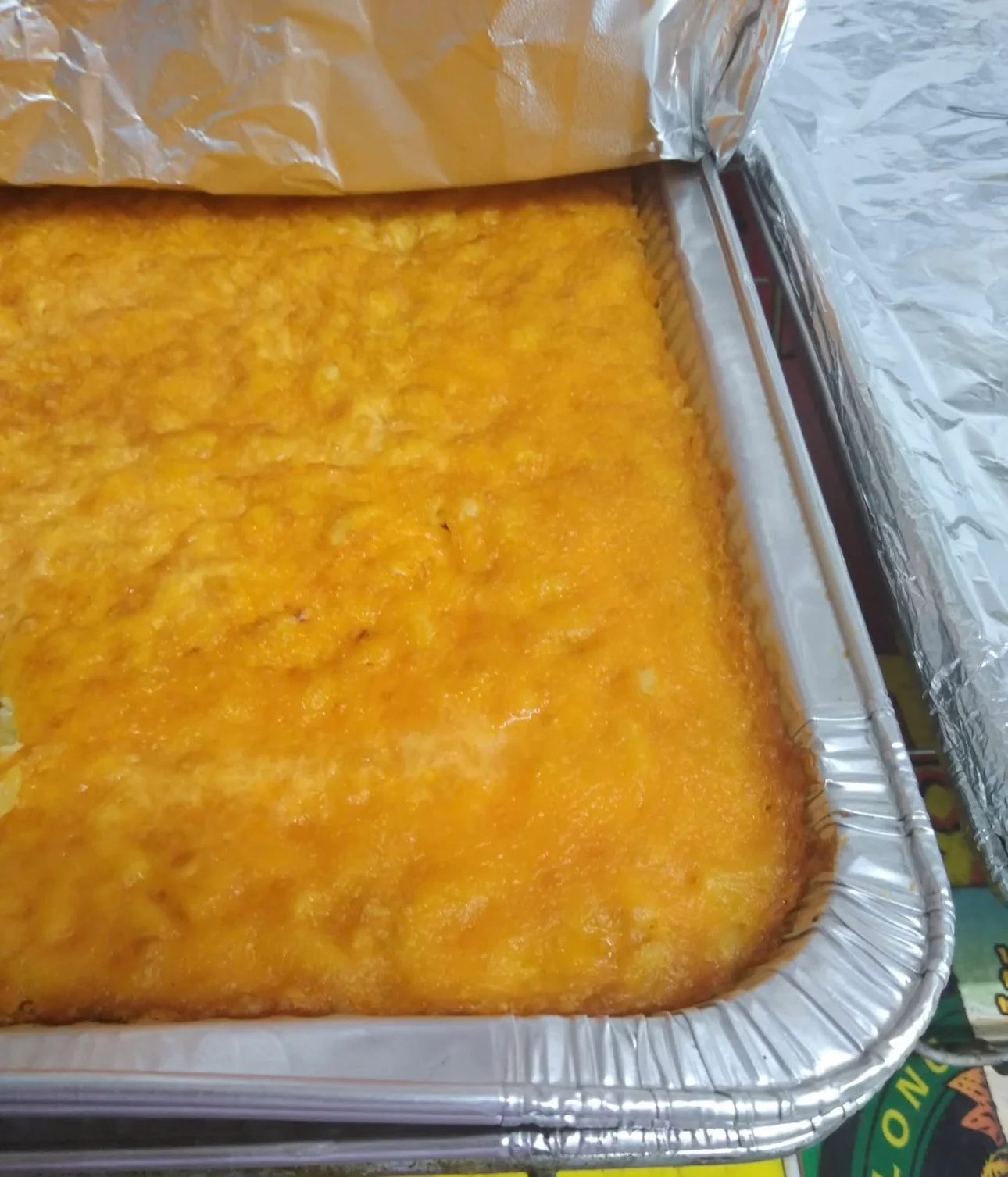 A close-up of a casserole dish filled with a golden-brown cheesy baked dish, with melted cheese covering the top.