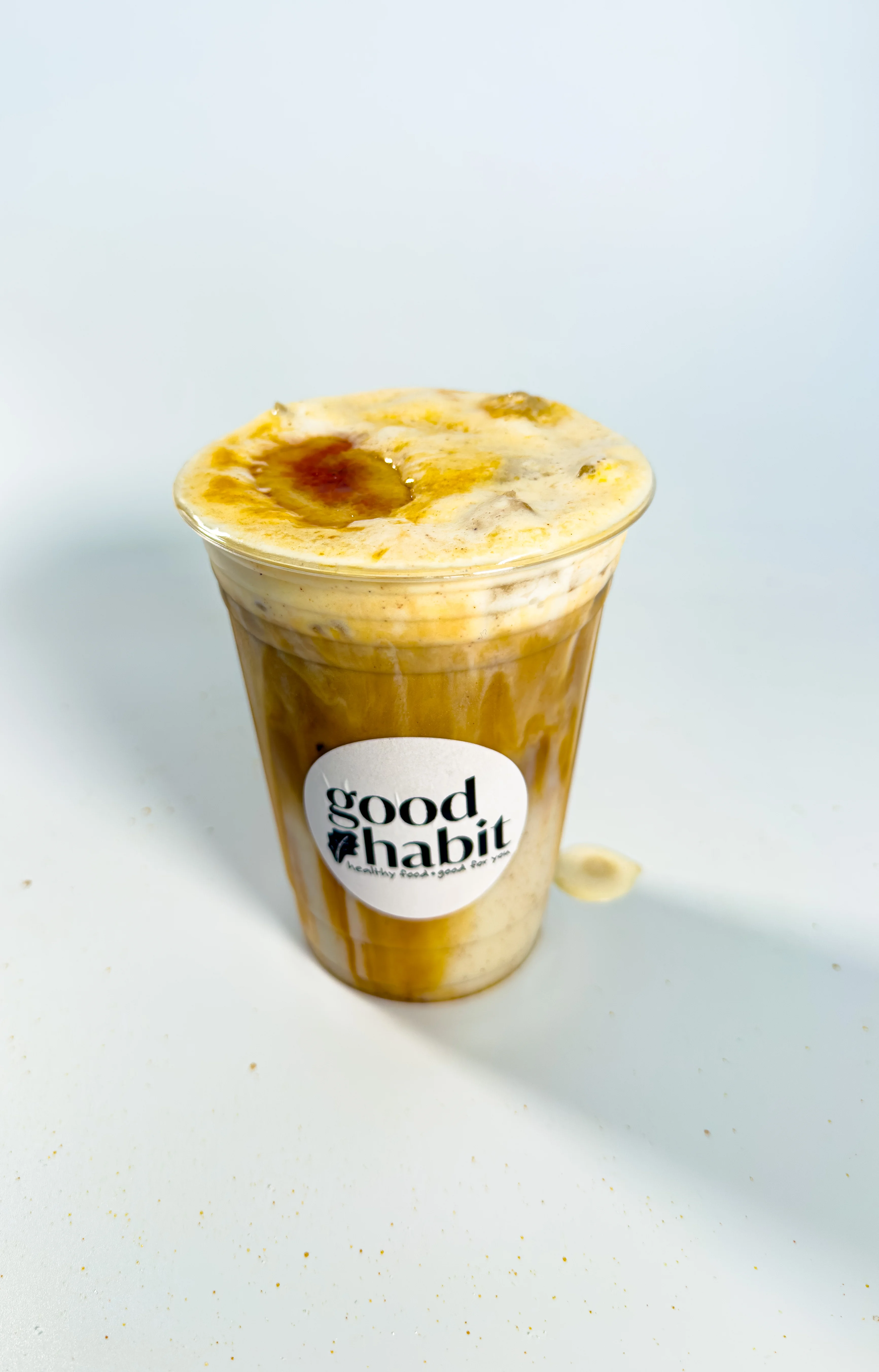 Iced coffee drink with creamy foam and caramel drizzle
