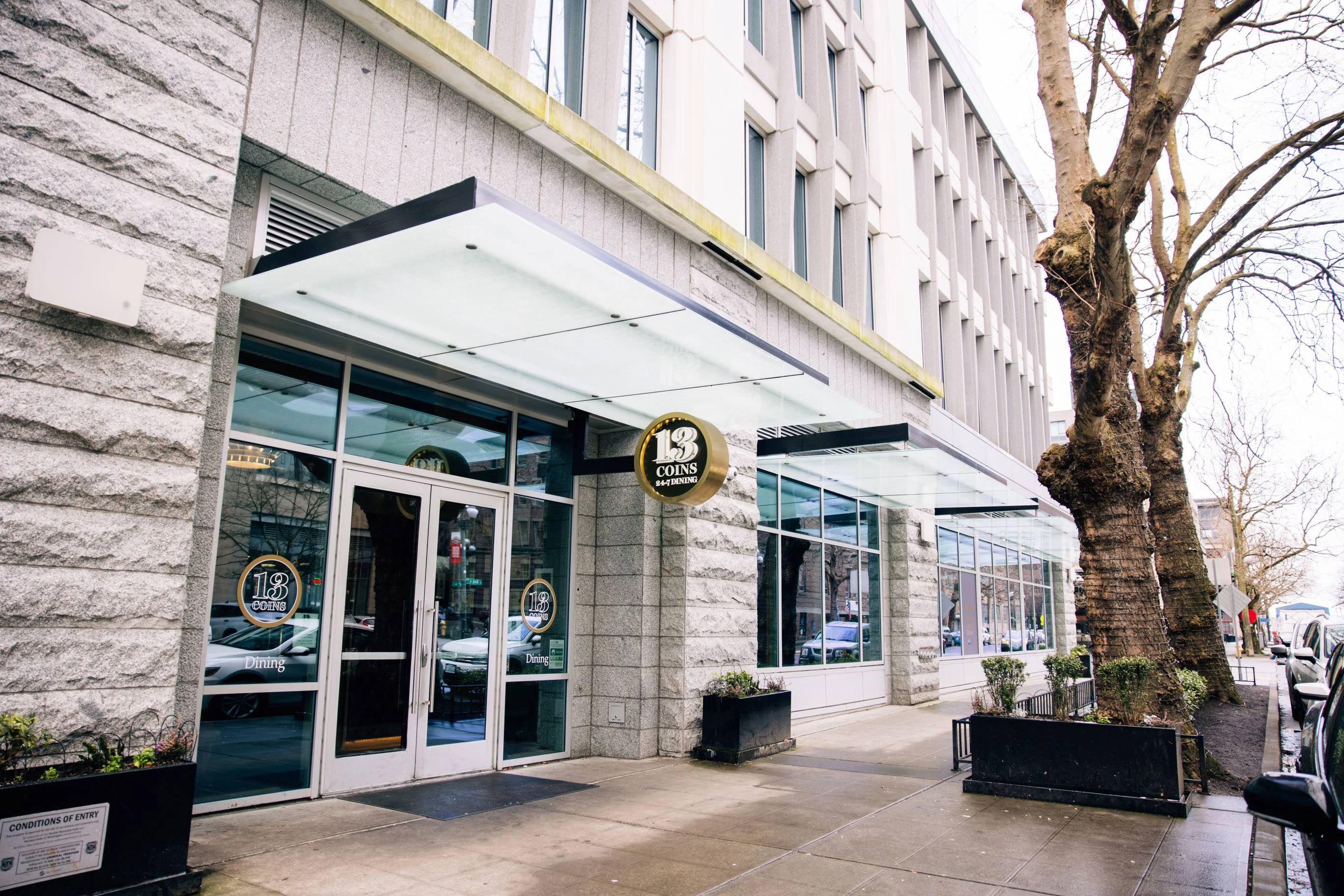 Exterior view of 13 Coins restaurant with glass entrance and signage.