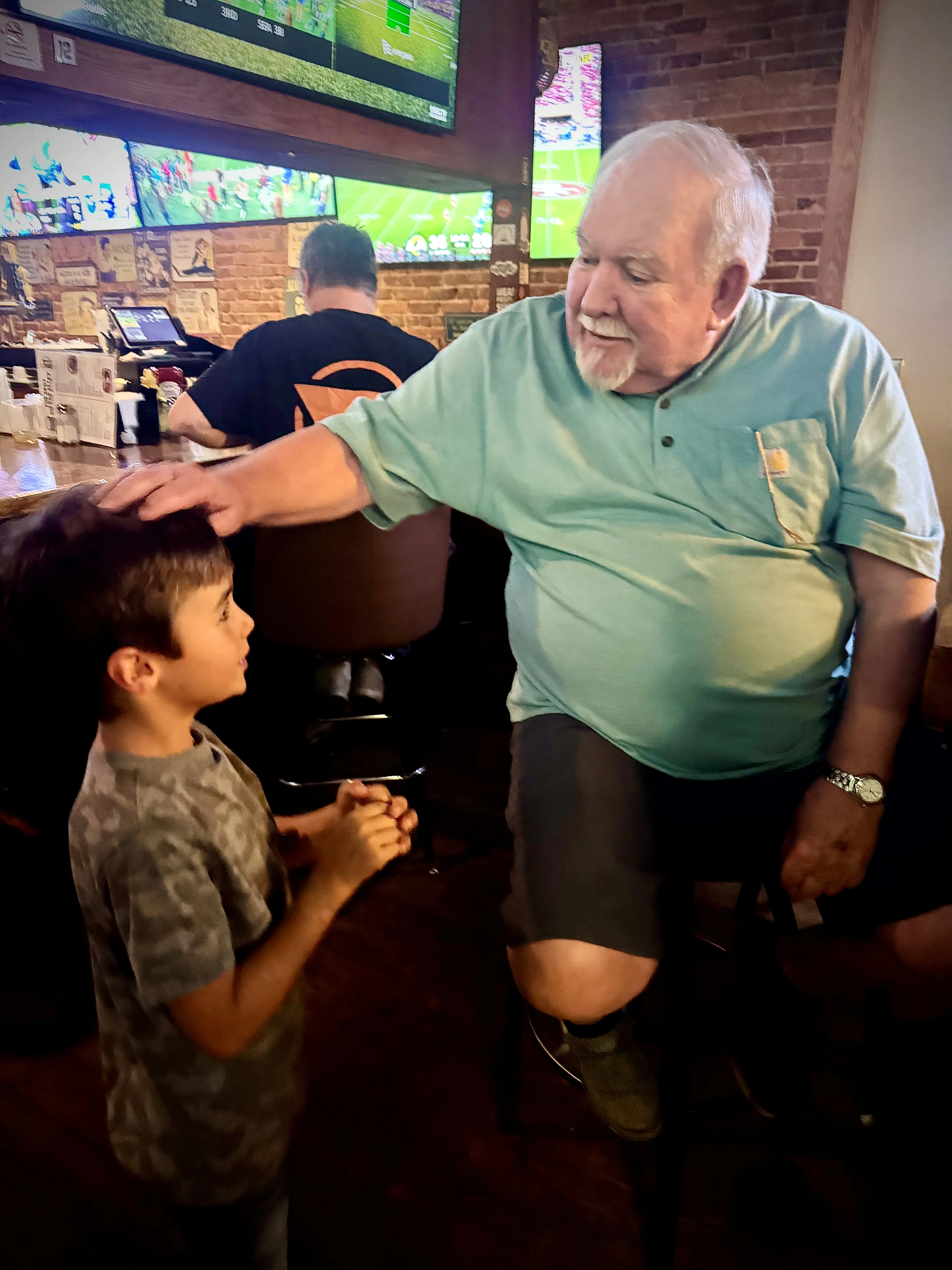 Heartwarming interaction between a child and an older man in a restaurant